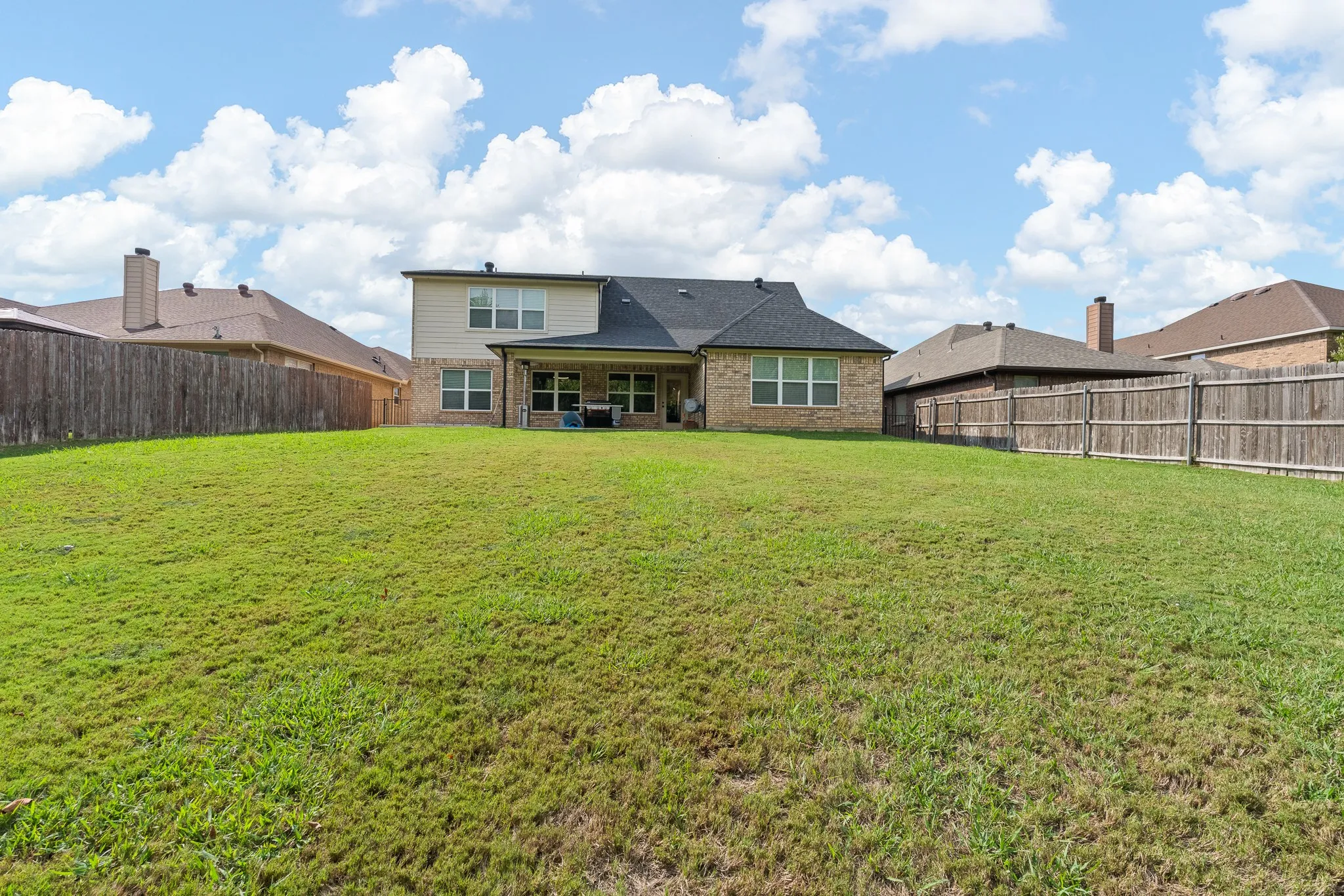 Expansive green lawn with a privacy fence