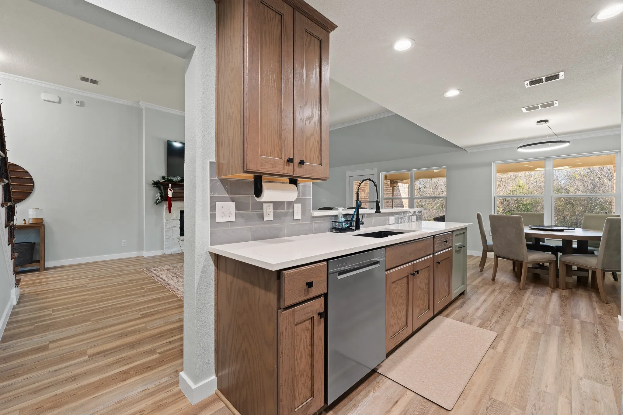 Built-in cabinetry, stainless steel sink, pull-down faucet, and wood-finish flooring