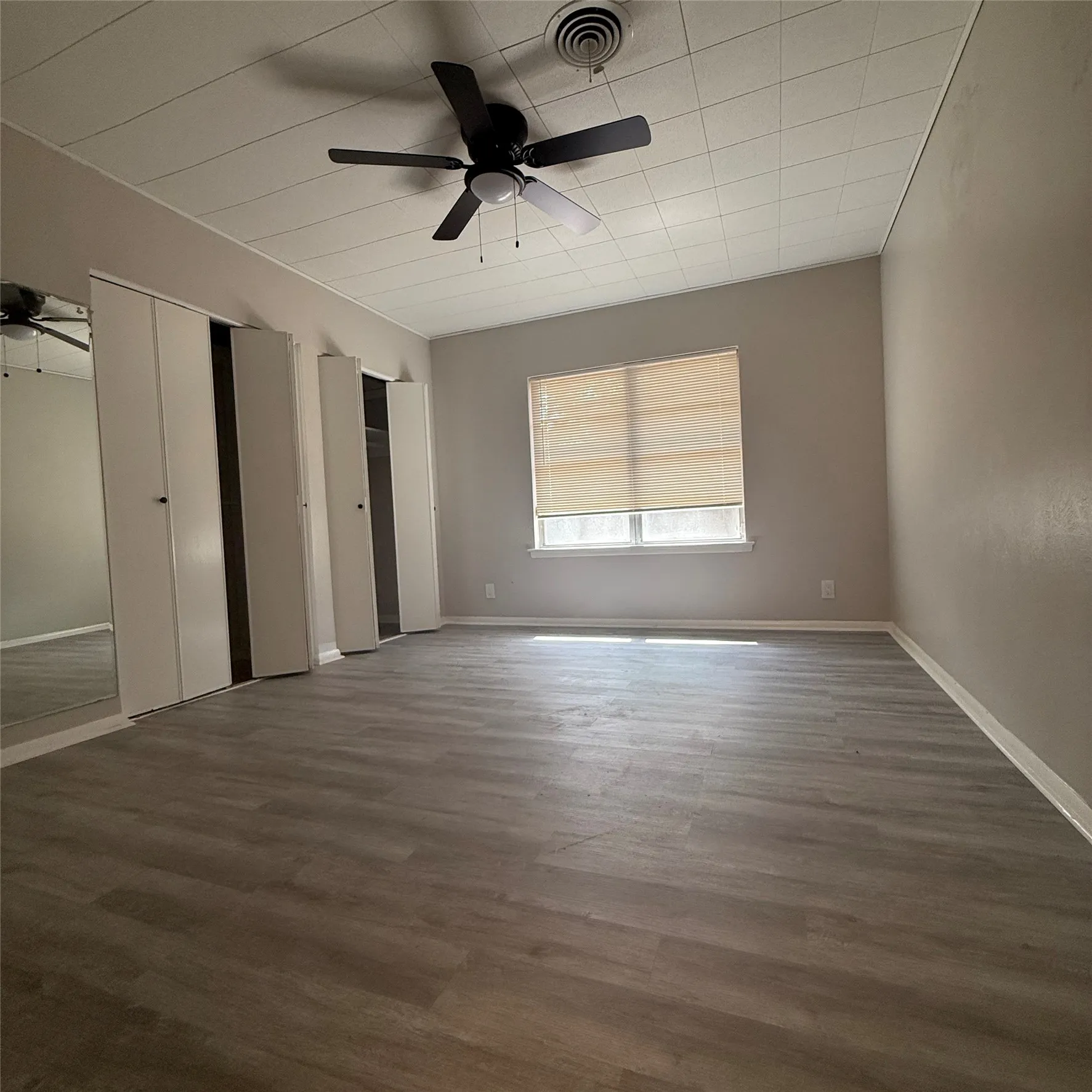 Wood-finish flooring with neutral wall tones and a ceiling fan