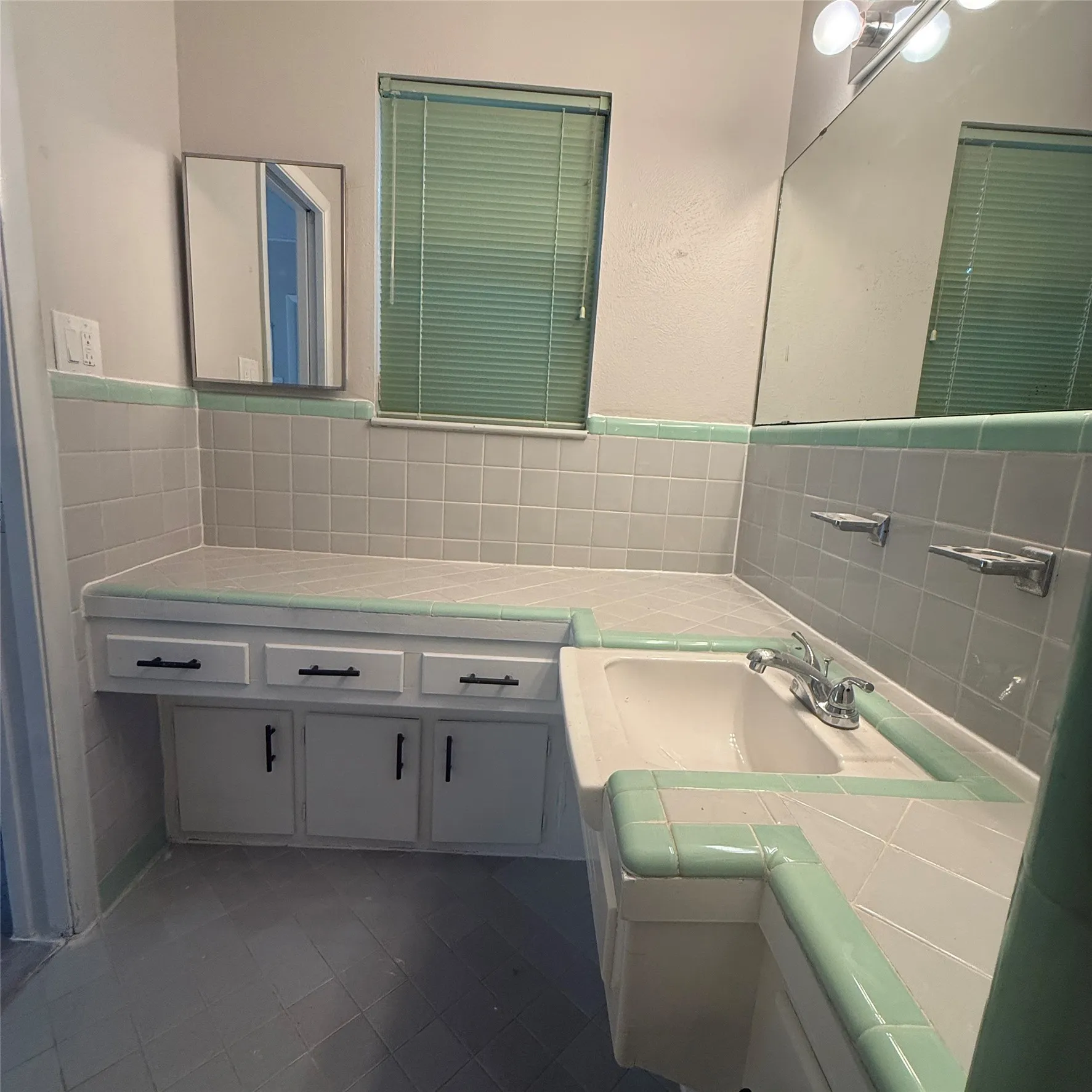Built-in vanity with three drawers and two cabinet doors, integrated sink, and wall-mounted mirror