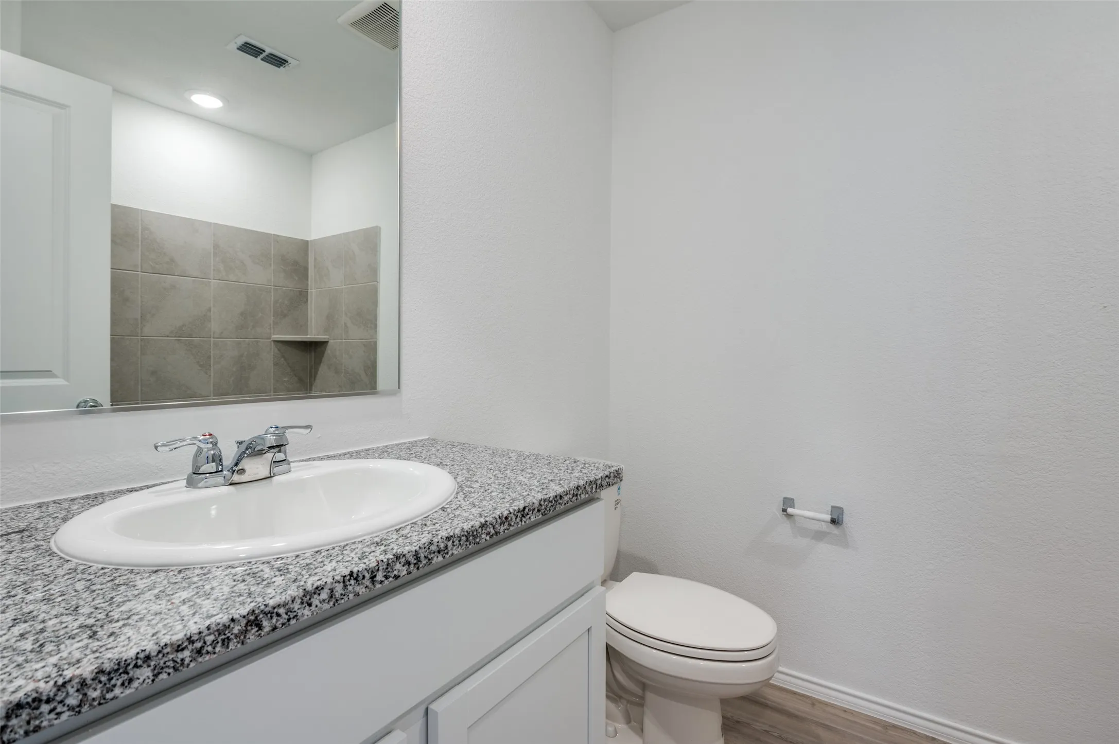 Bathroom with toilet, vanity, and hardwood / wood-style flooring