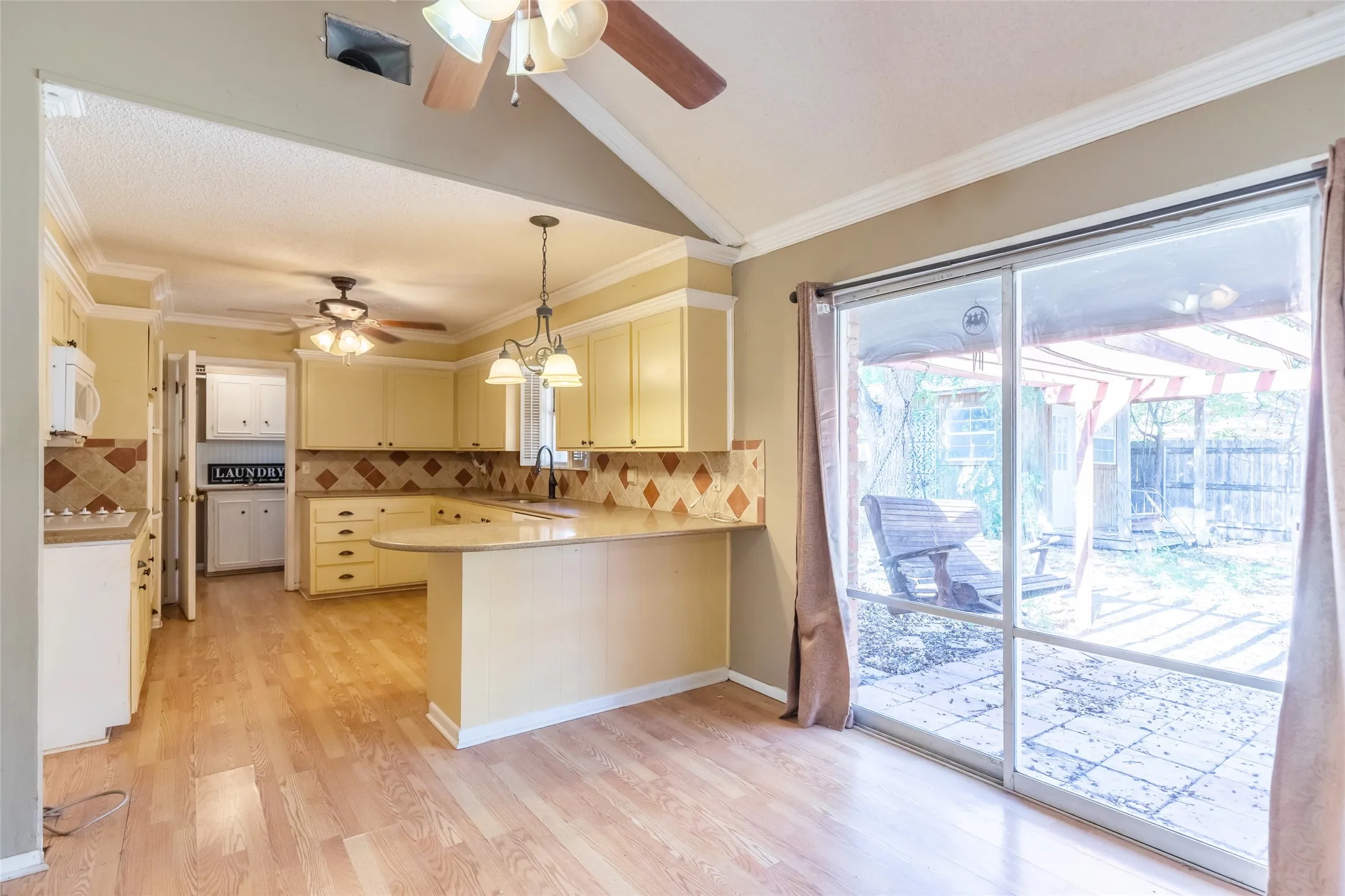 Kitchen featuring light-toned cabinetry, tile backsplash, and wood-finish​​‌​​​​‌​​‌‌​‌‌​​​‌‌​‌​‌​‌​​​‌​​ flooring