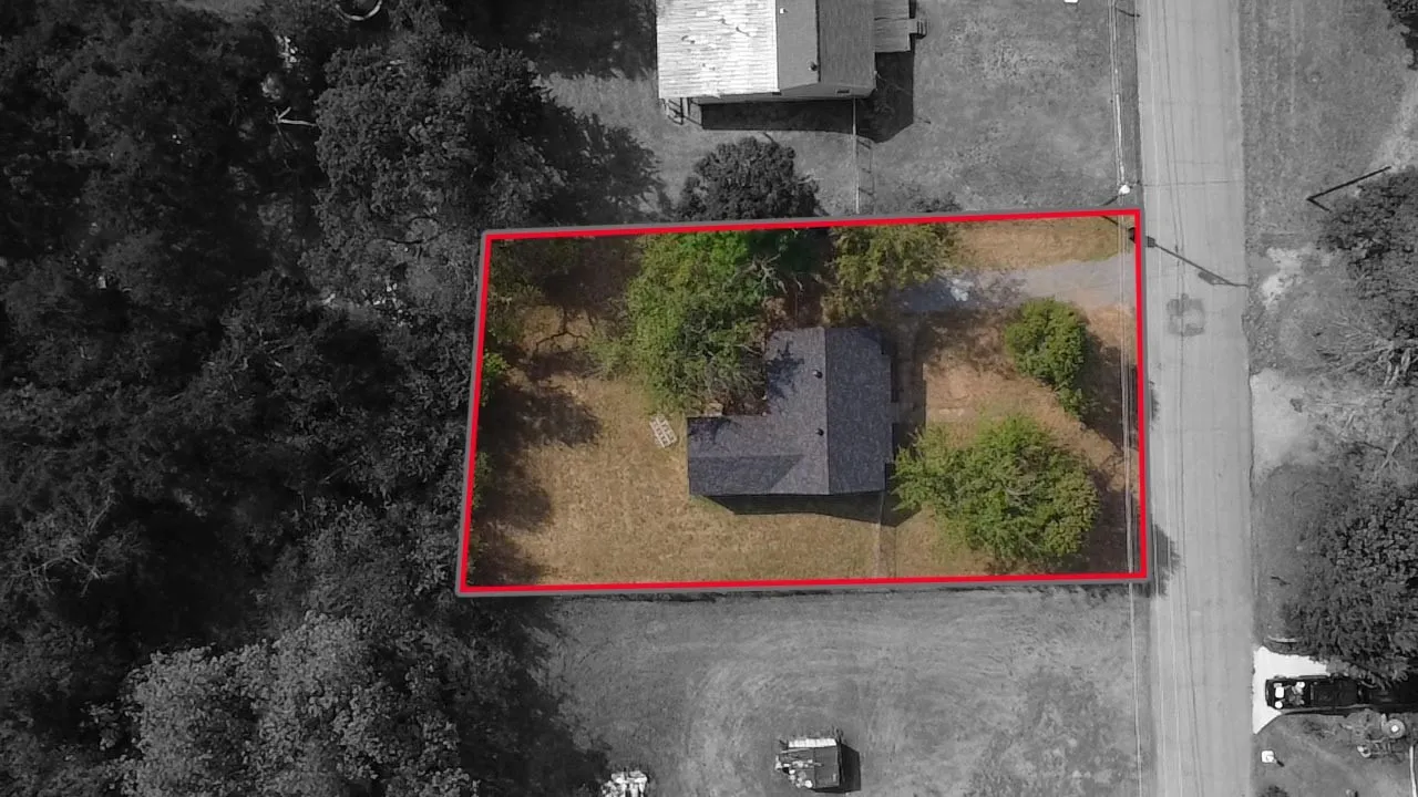 Property parcel with established trees, a detached structure, and street proximity