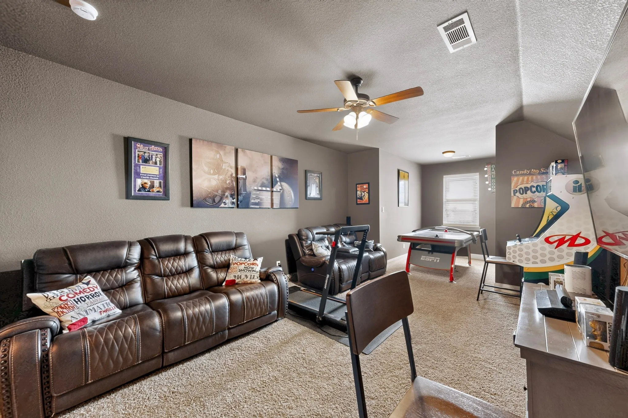Carpeted room with sloped ceilings, ceiling fan, and recessed lighting