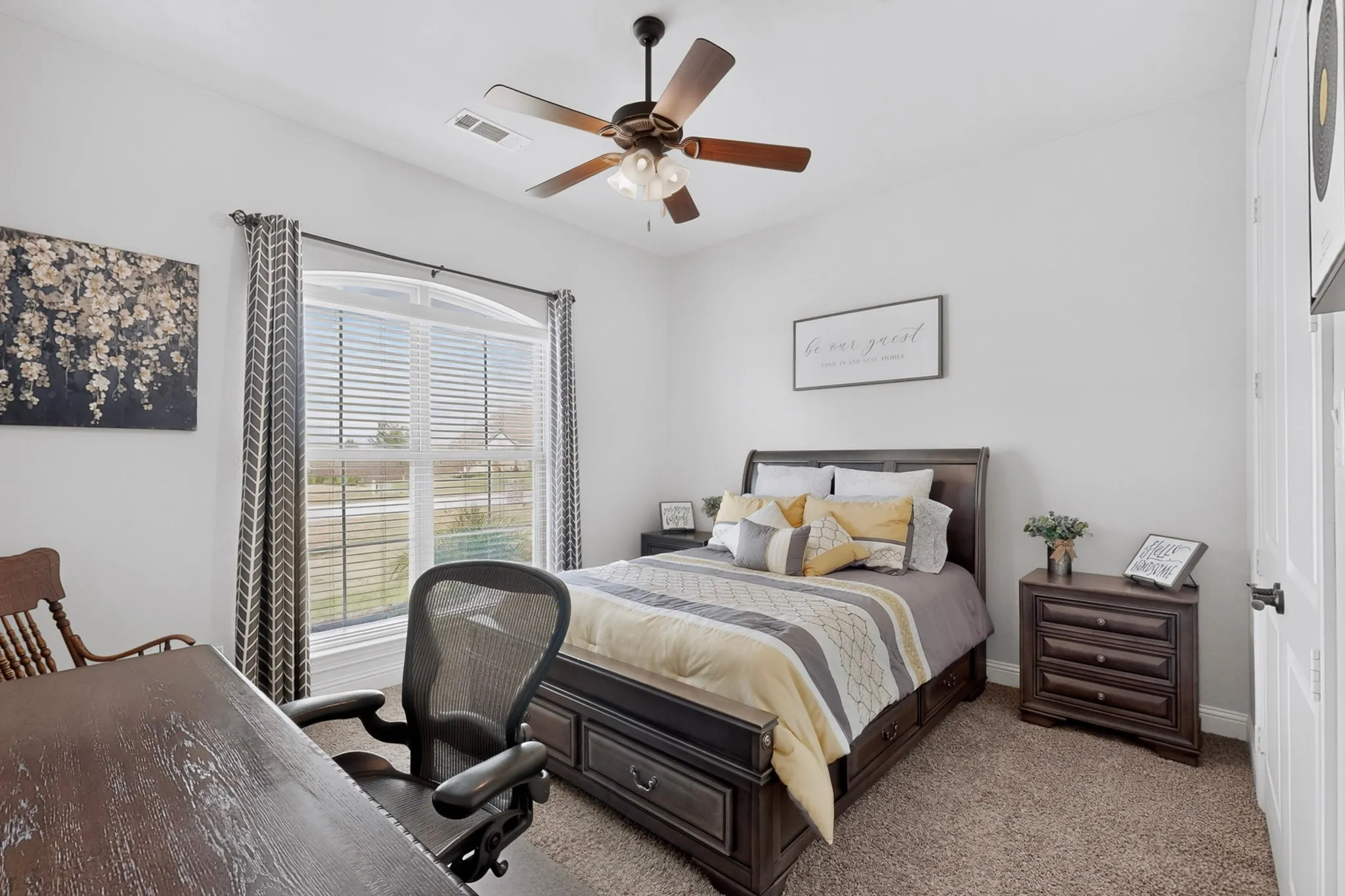 Carpeted room with a ceiling fan, a window with blinds and drapes, and a white paneled door