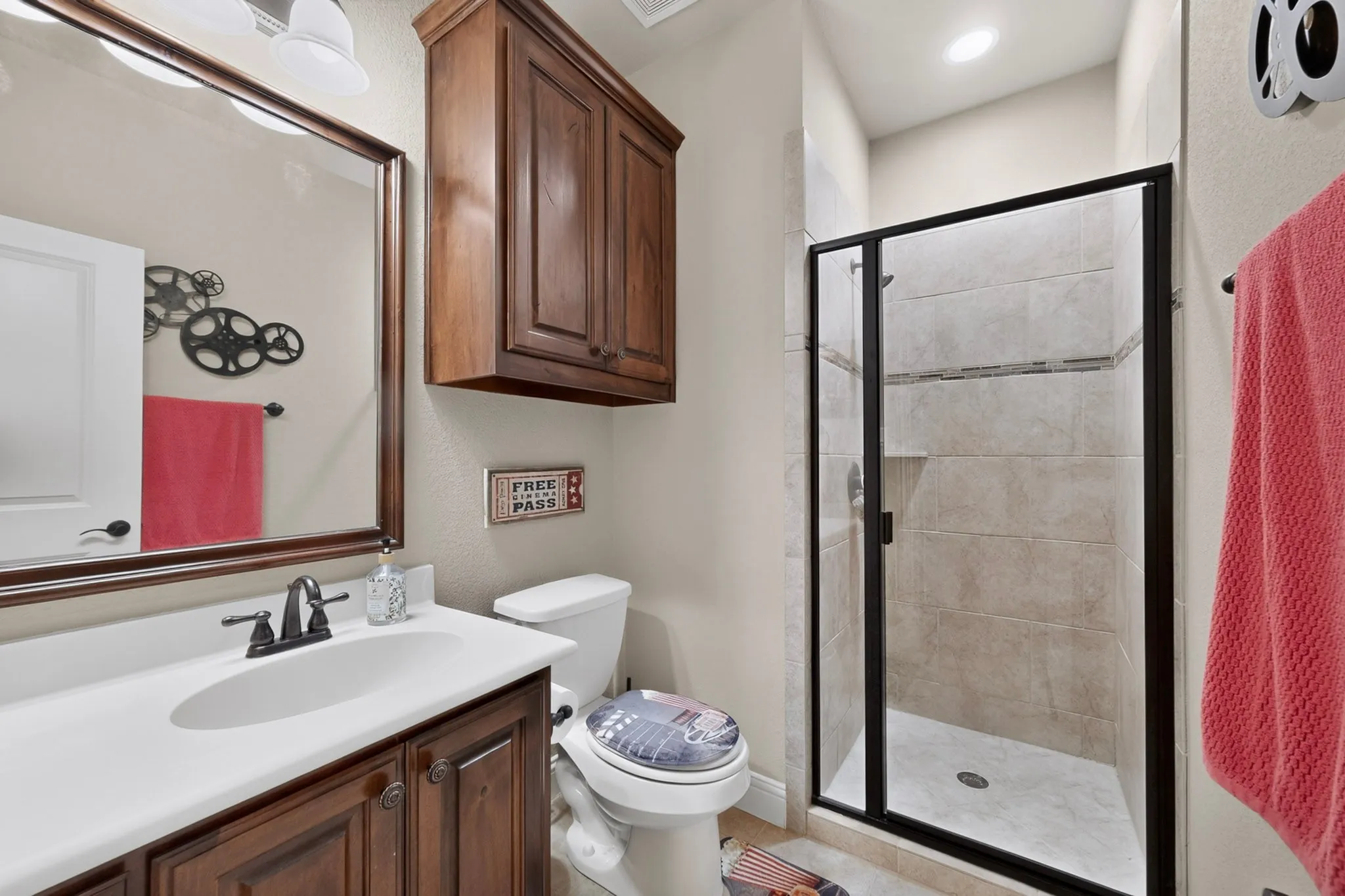 Vanity with dark wood cabinetry, white countertop, and framed mirror