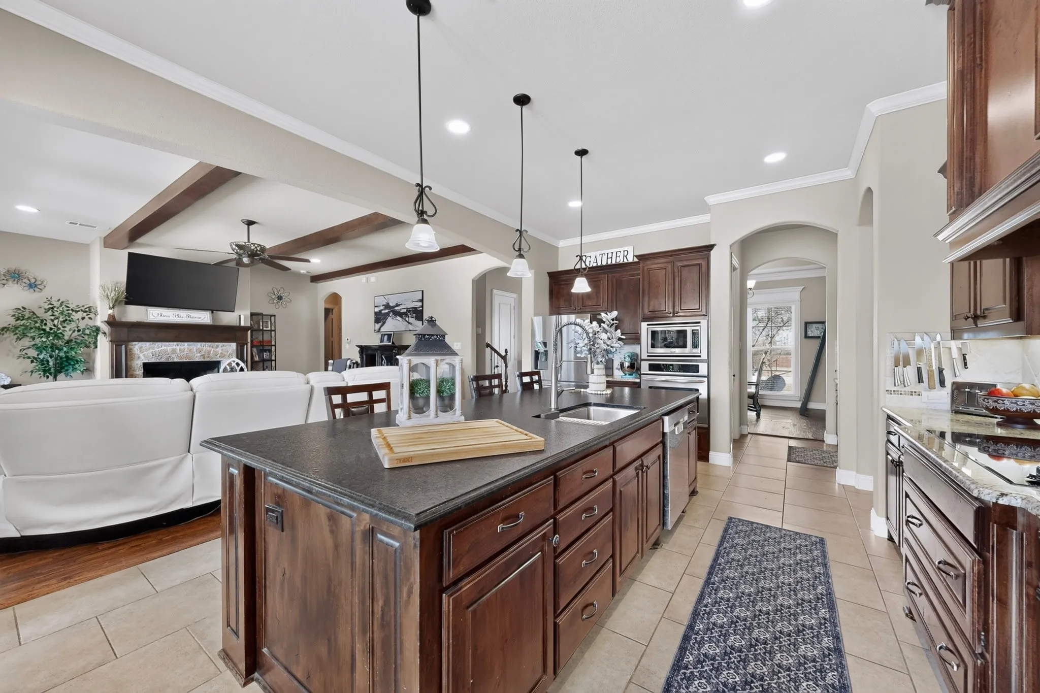Expansive kitchen island with dark countertops and wood-finish cabinetry