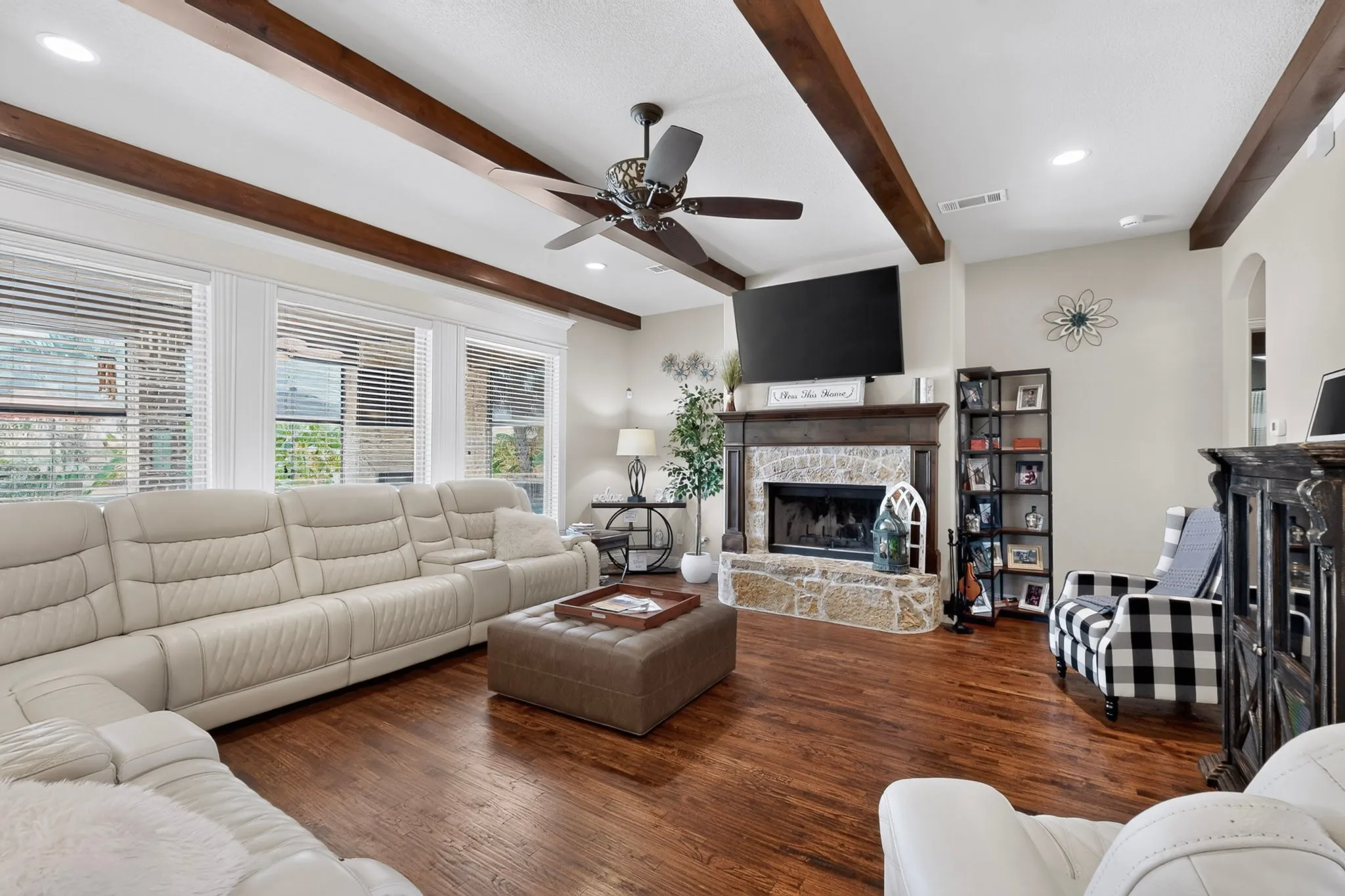 Warm wood-finish flooring complemented by exposed ceiling beams