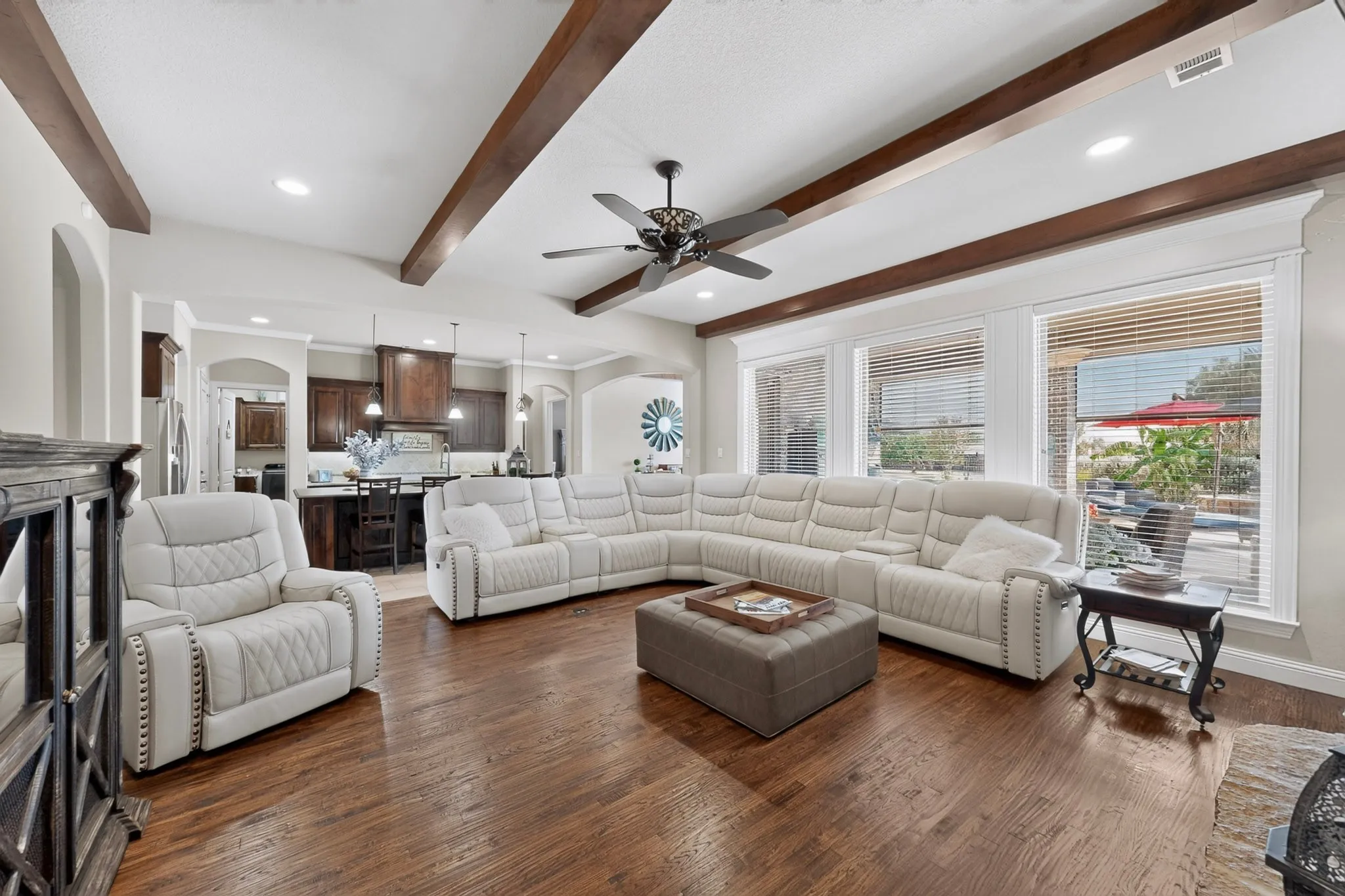 Wood-finish flooring with exposed ceiling beams and recessed lighting