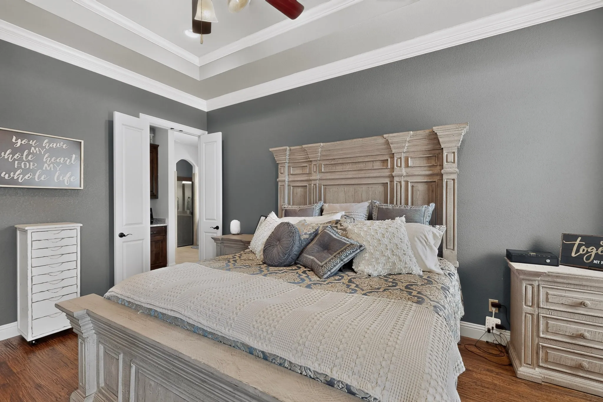 Tray ceiling with crown molding, wood-finish flooring, and white interior doors