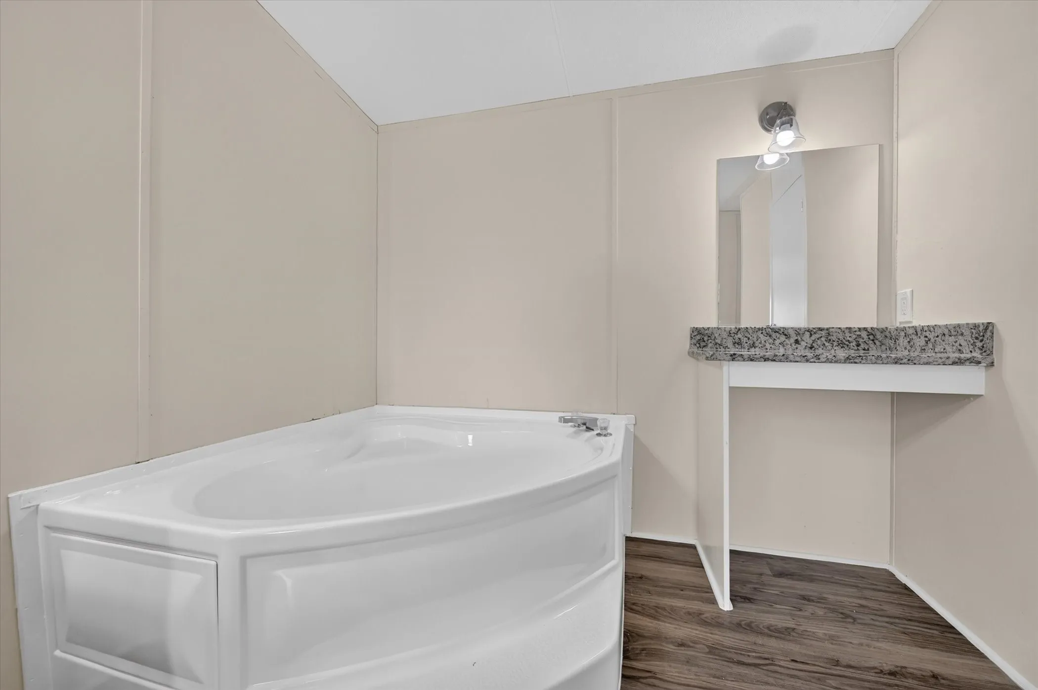 Corner soaking tub with deck-mounted faucet