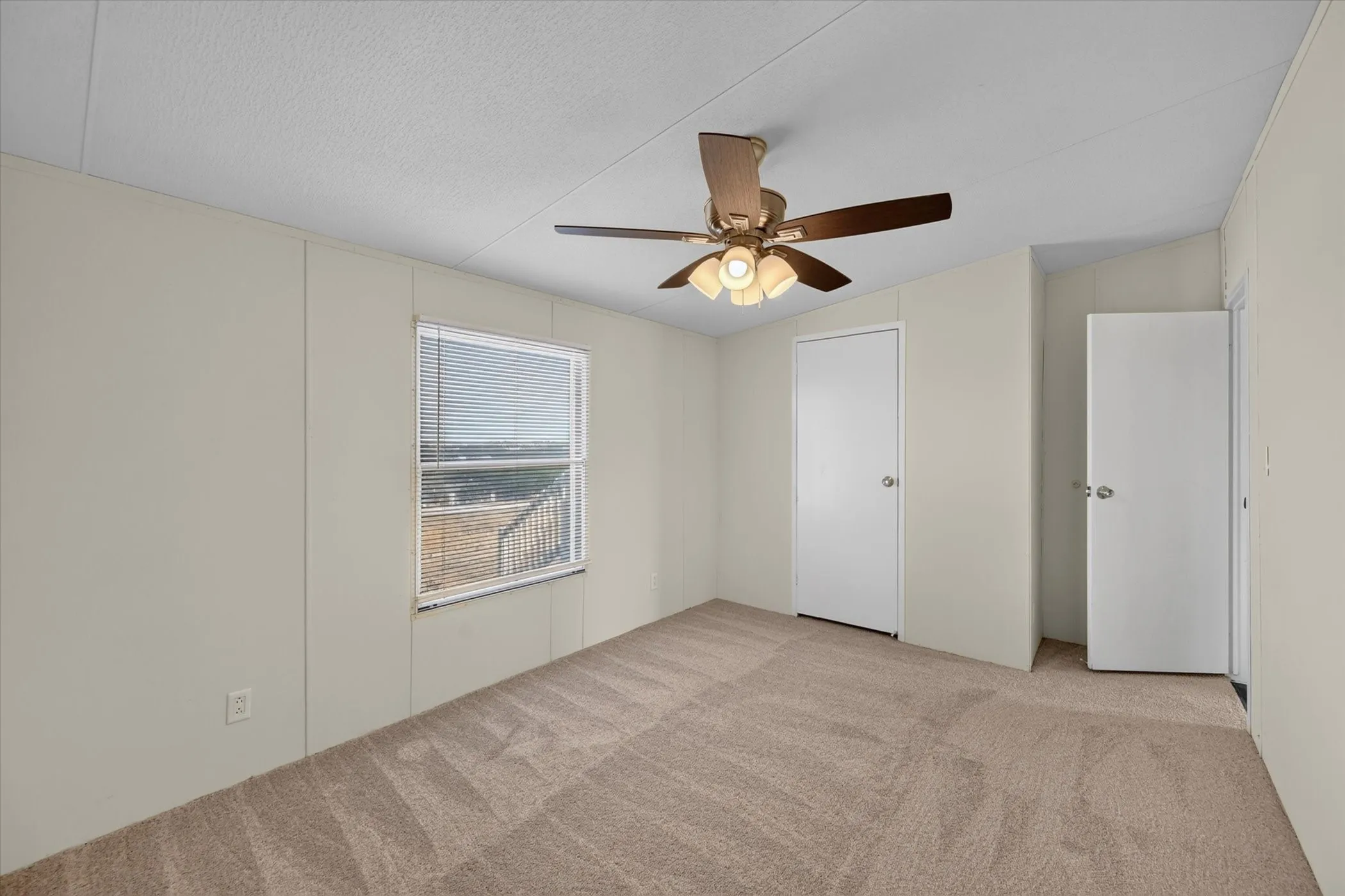 Carpeted flooring, ceiling fan with integrated lighting, window with blinds, and white panel doors