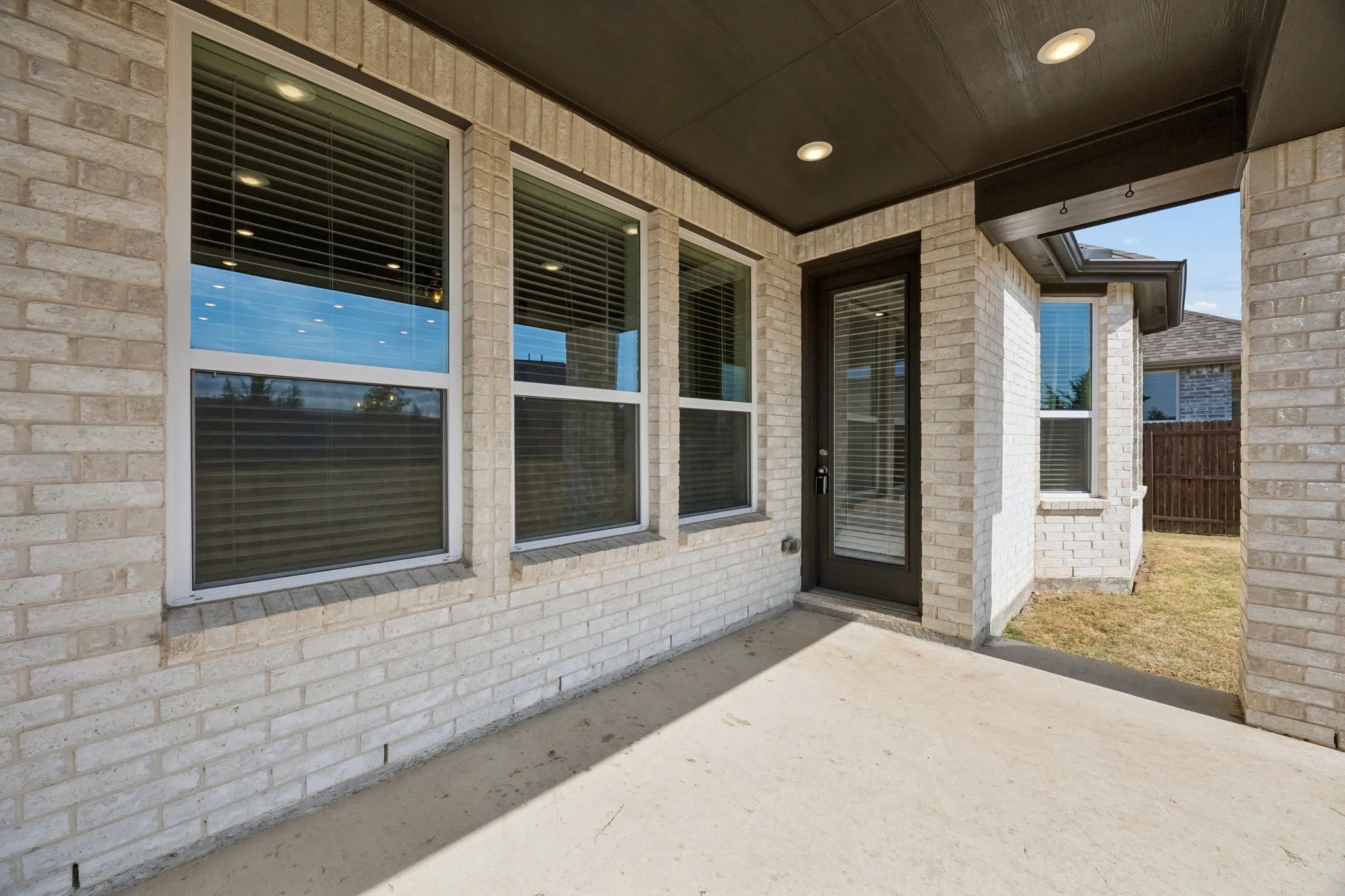 Covered patio featuring a light brick exterior and recessed lighting