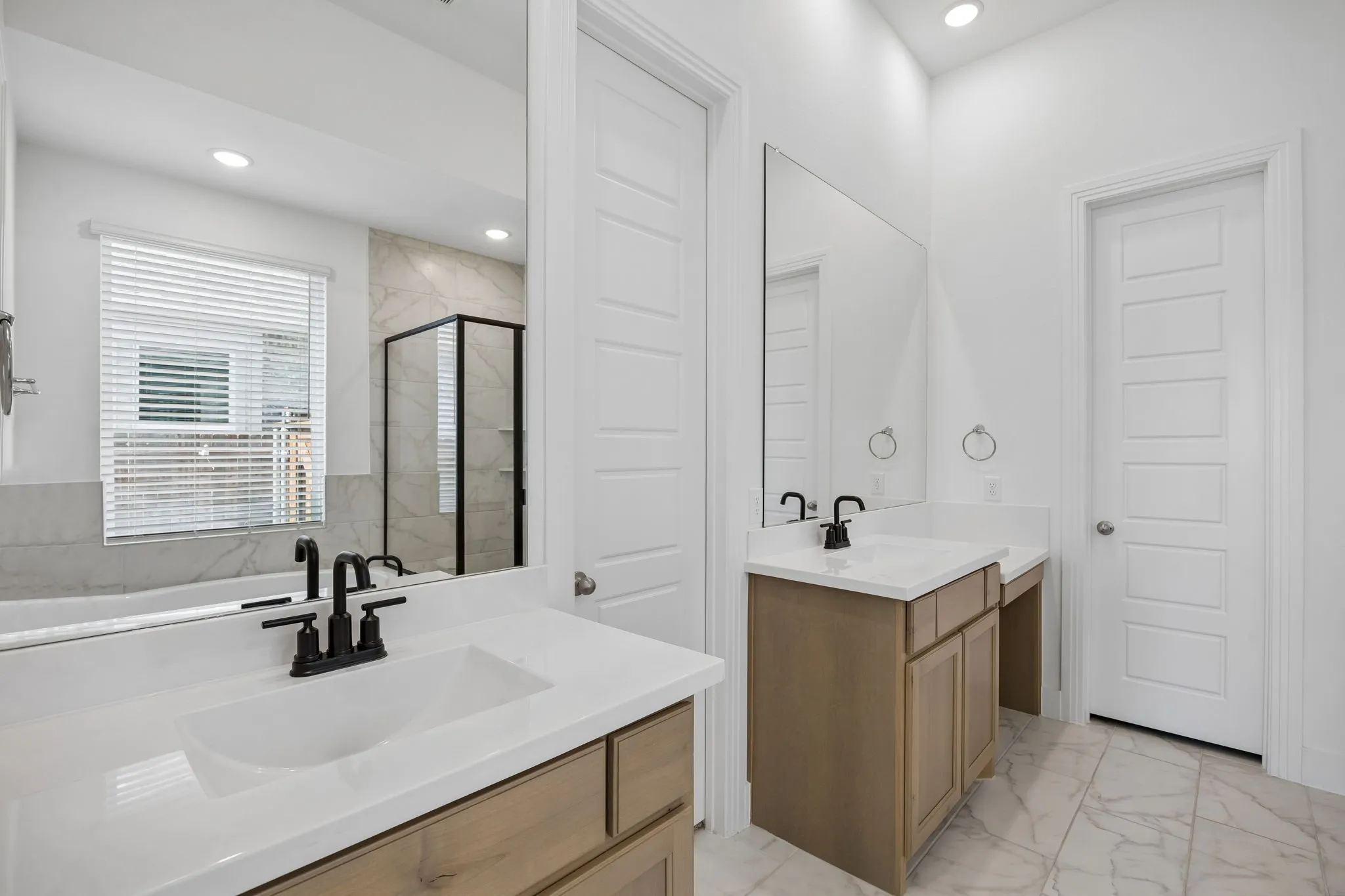 Primary Bathroom featuring Vanity with integrated sink, light-toned wood cabinetry, and a white countertop