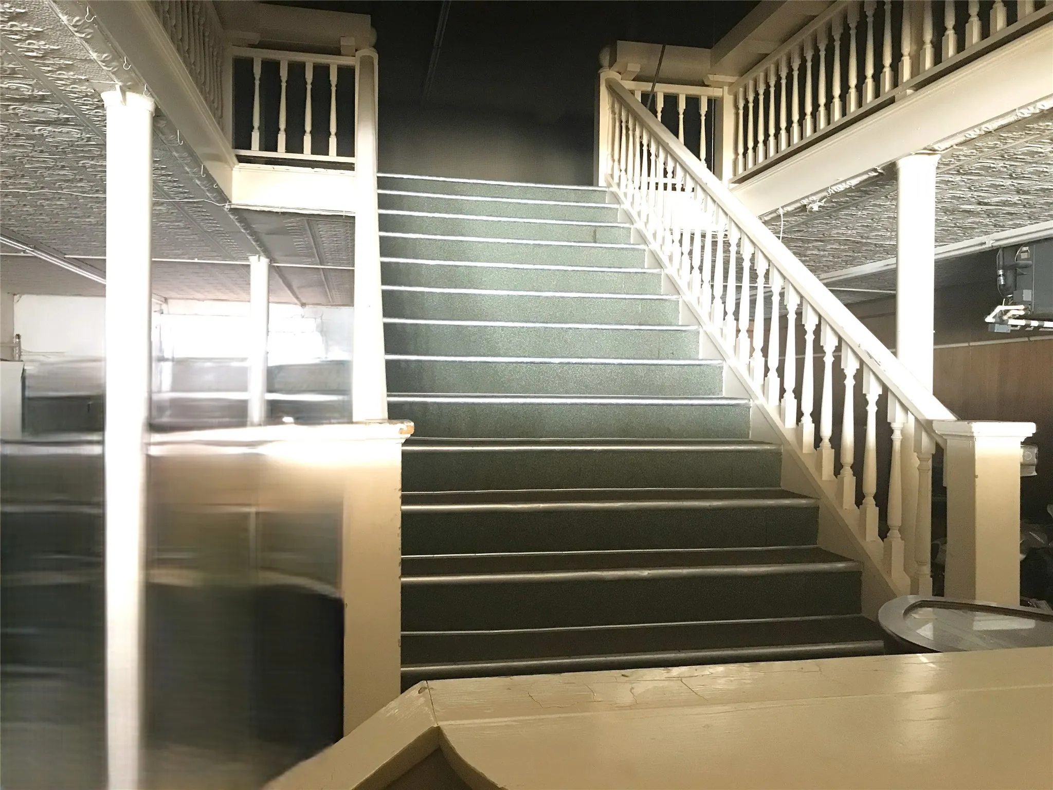 Modern staircase featuring wide treads with dark finish, white balusters and handrails, and recessed lighting throughout