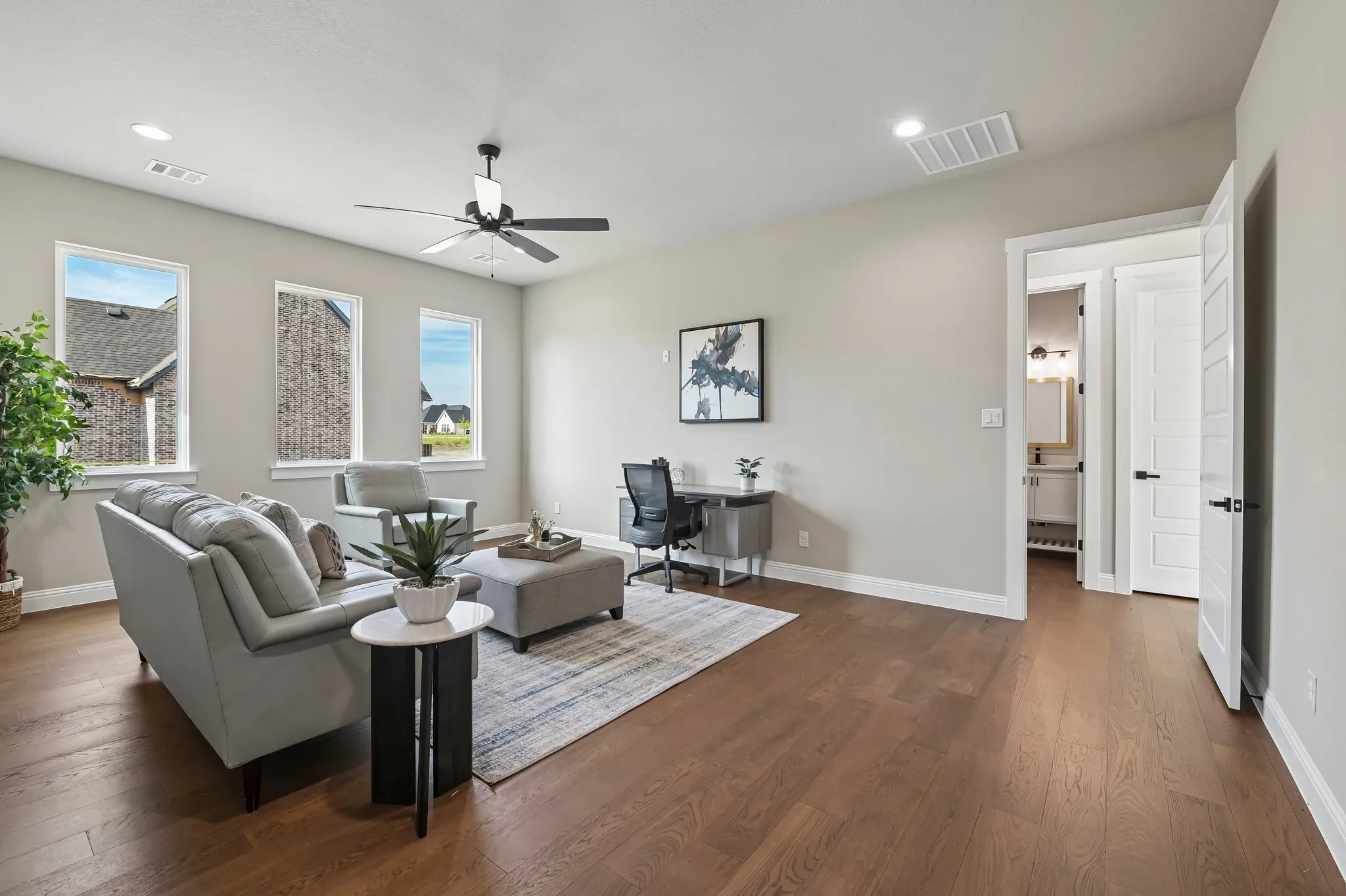Warm wood-finish flooring, recessed lighting, and a ceiling fan with light fixture