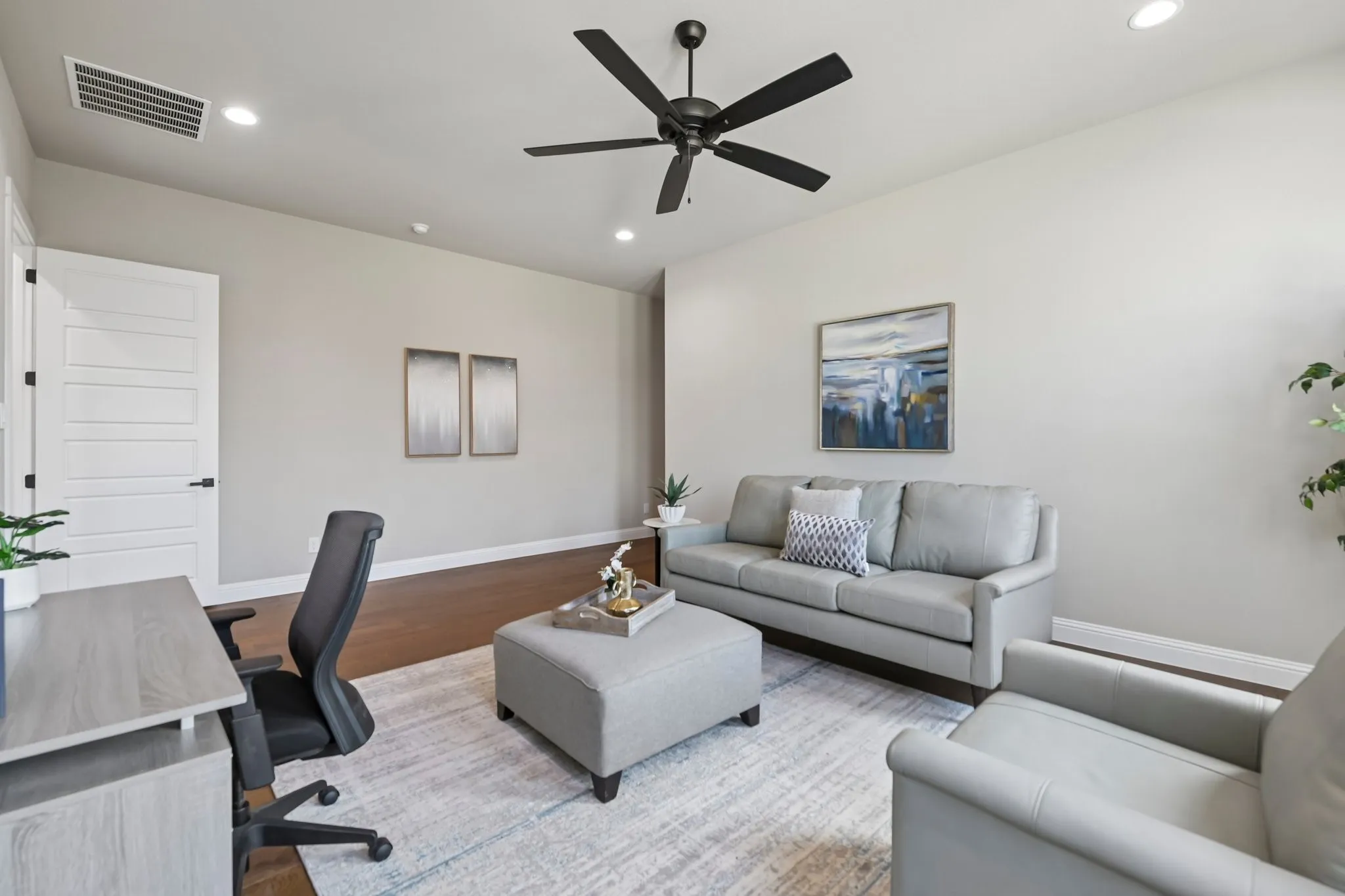 Neutral wall color, wood-finish flooring, recessed lighting, ceiling fan, and white five-panel interior door