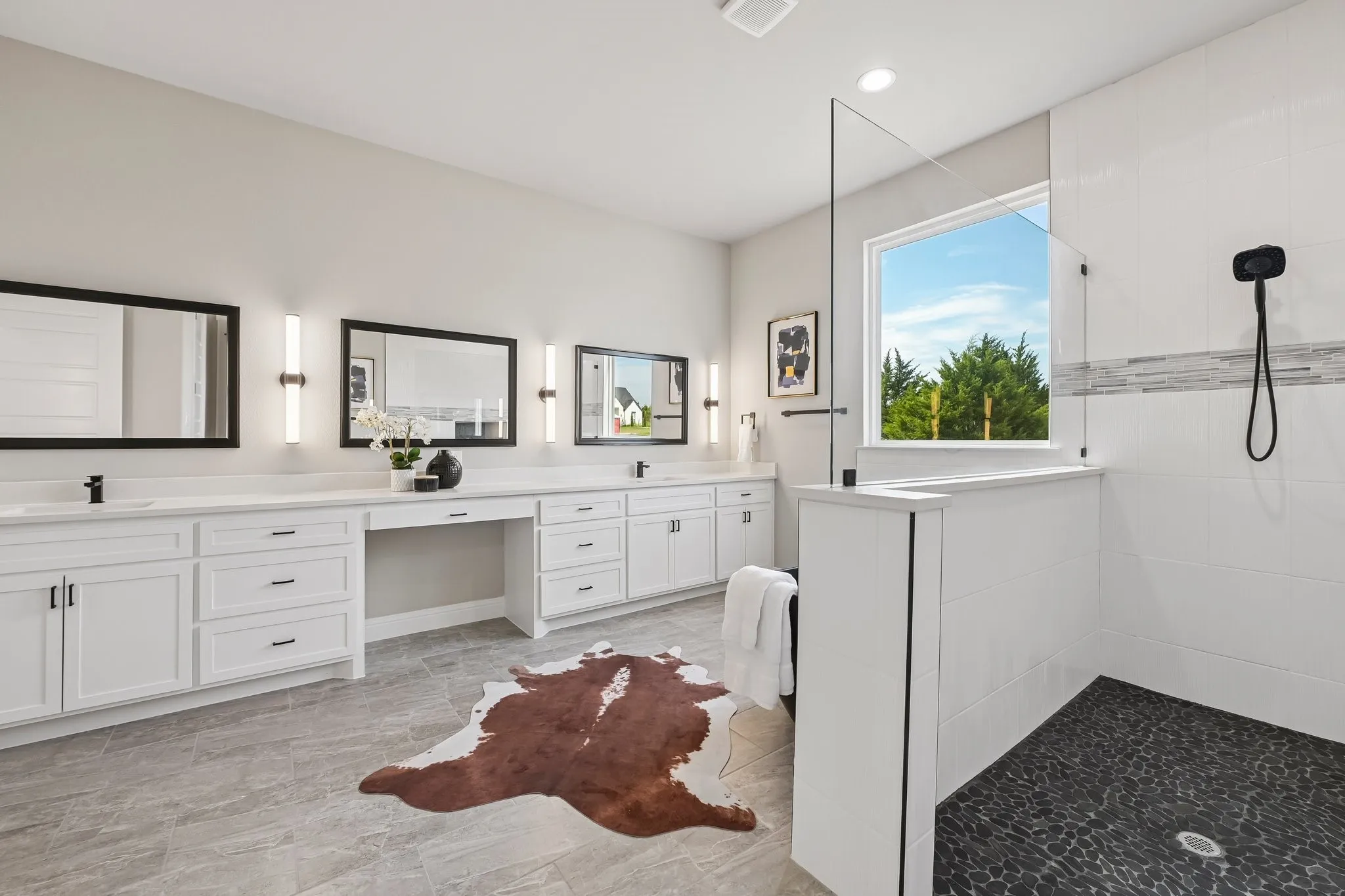 Double vanity with white cabinetry, built-in makeup area, and individual framed mirrors