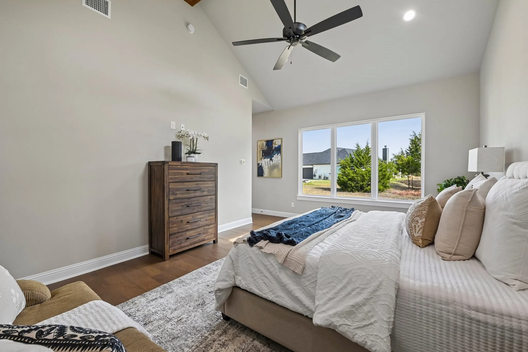 Vaulted ceiling featuring a ceiling fan, recessed lighting, and wood-finish flooring