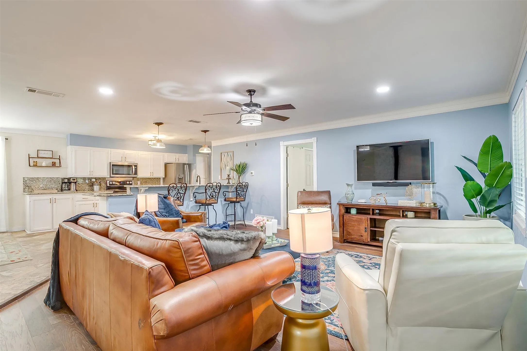 Open-concept living area featuring wood-finish flooring, recessed lighting, and a ceiling fan