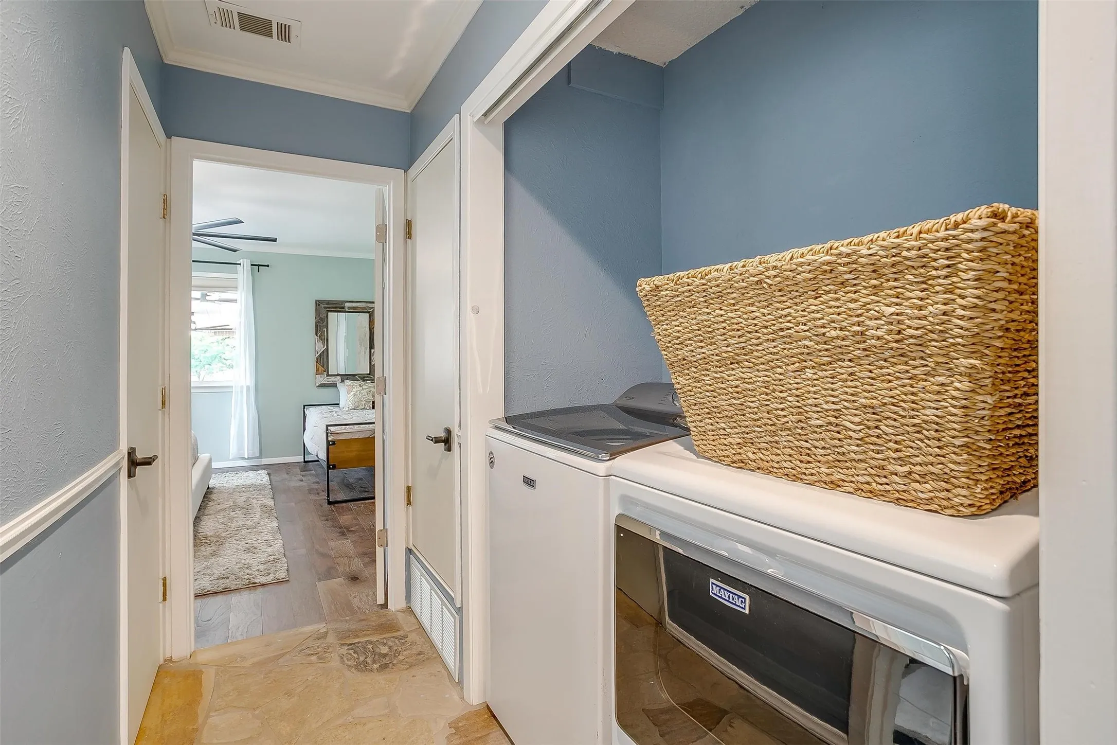 Hallway with light blue walls, white trim, and stone-finish flooring