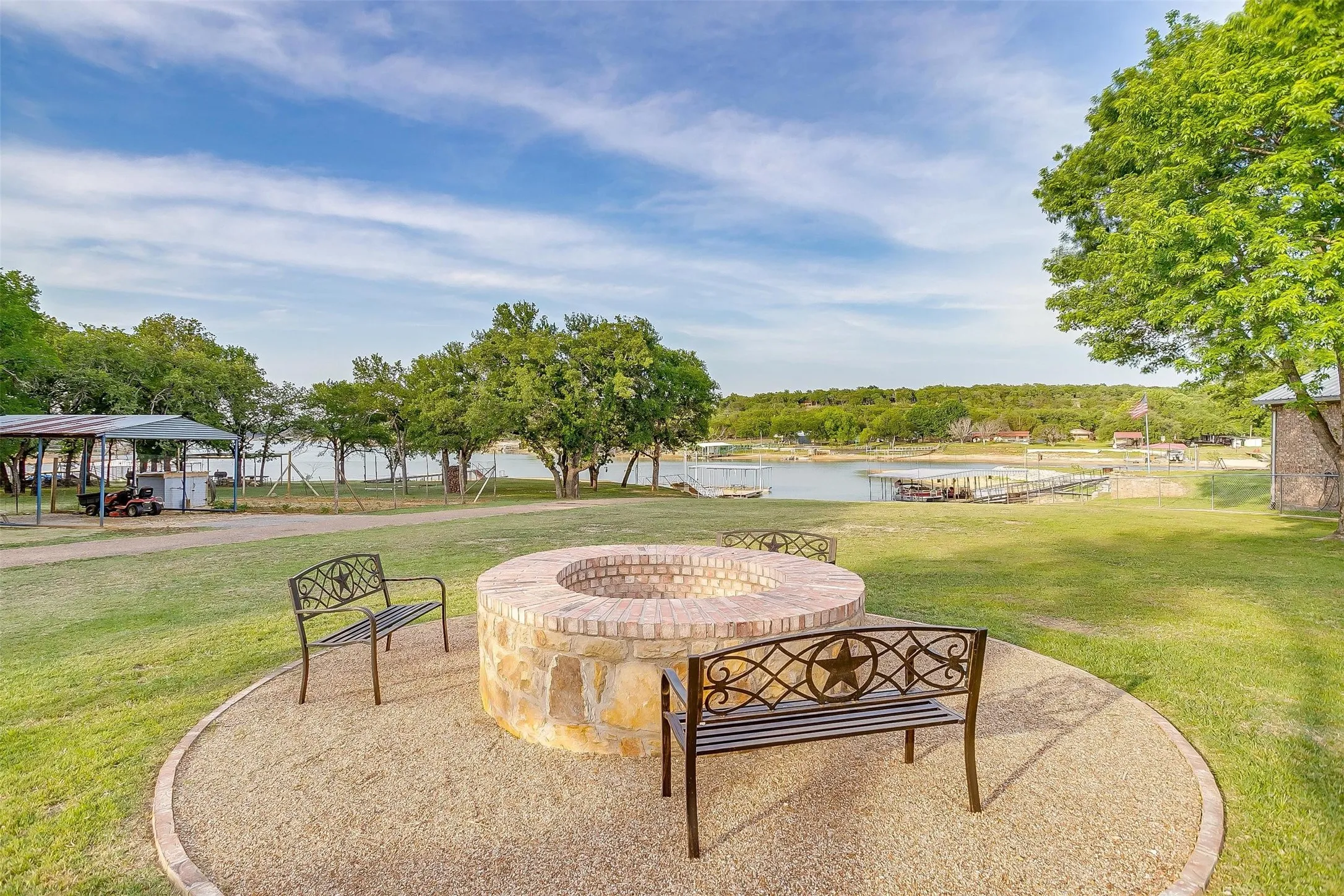 Stone-clad fire pit with a brick top, set on a gravel patio