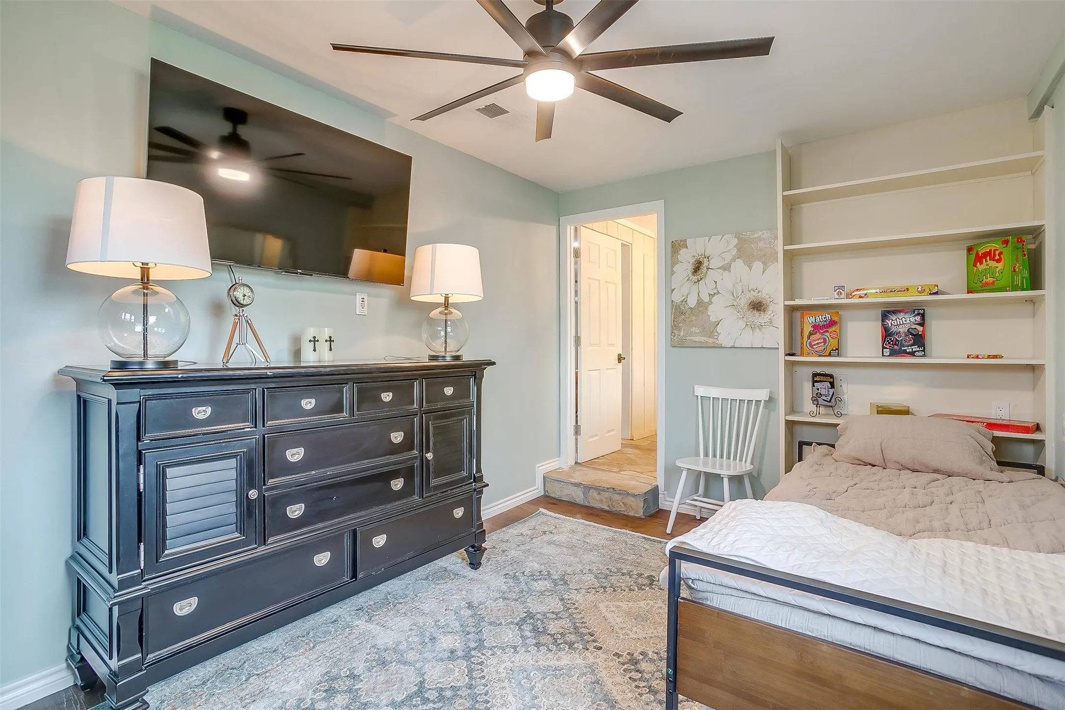 Hardwood flooring, ceiling fan, and built-in shelving