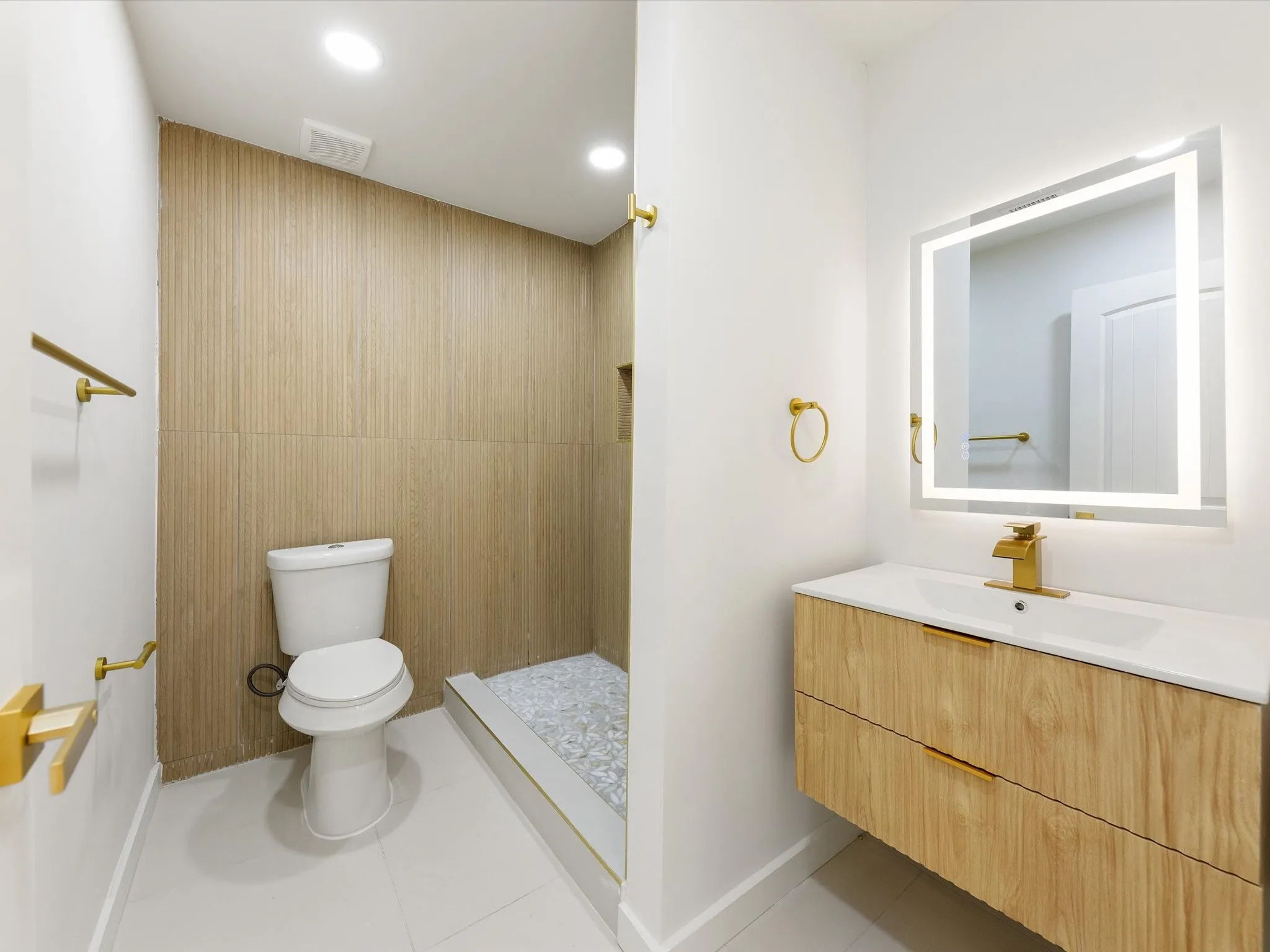 Floating wood-finish vanity with an integrated sink and gold-tone faucet