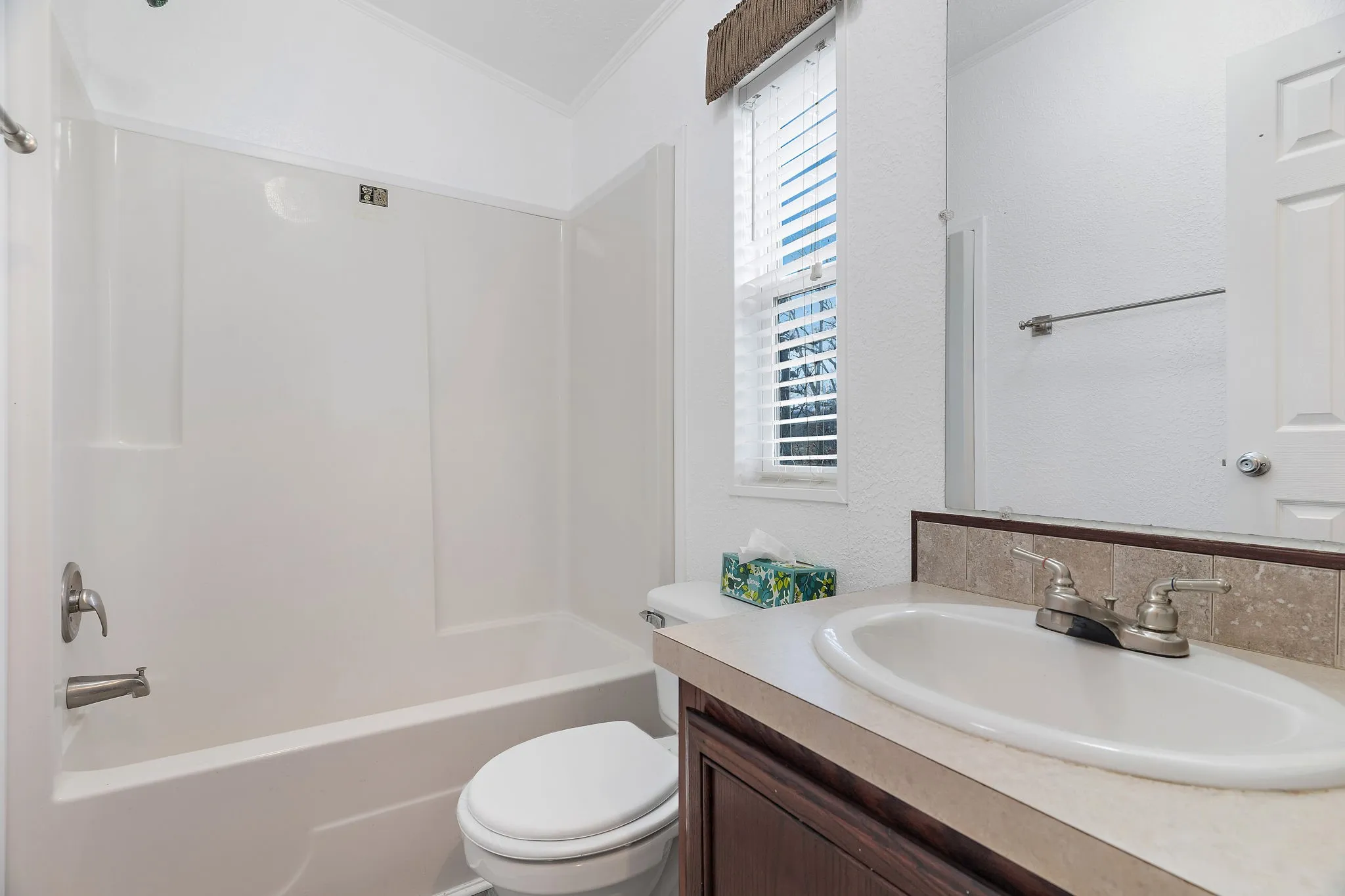 Full bathroom with shower / bath combination, vanity, toilet, and ornamental molding