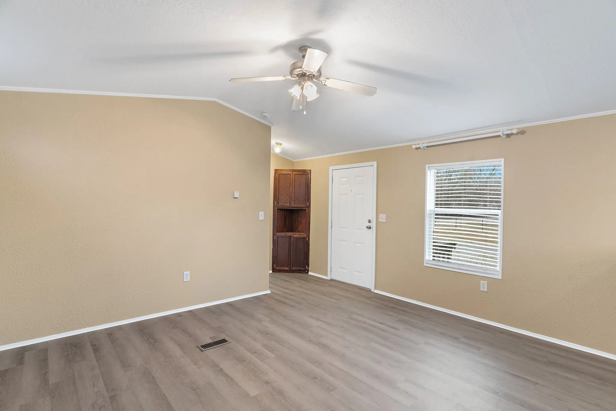 Unfurnished room featuring ceiling fan, lofted ceiling, crown molding, and light hardwood / wood-style floors