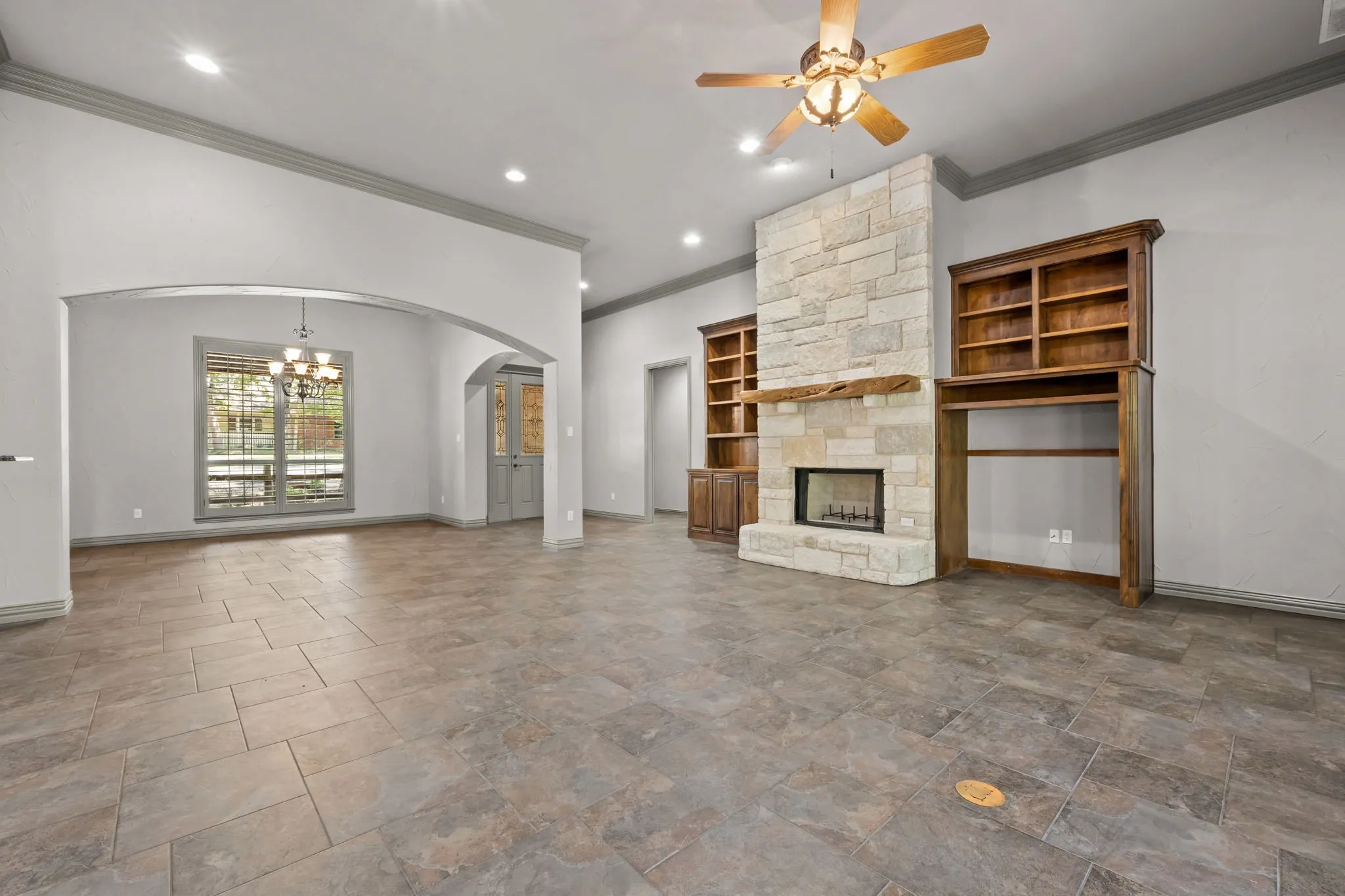 Stone tile flooring and stone fireplace with a wood mantle