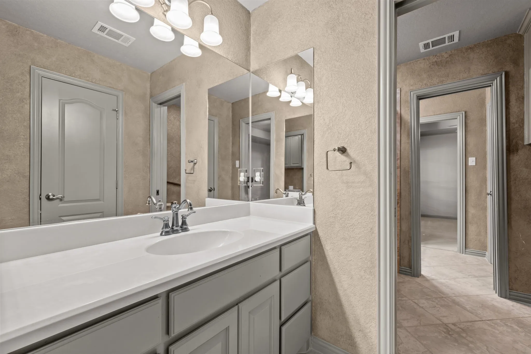 Jack and Jill bathroom .Vanity with an integrated sink, polished chrome faucet, and under-cabinet storage