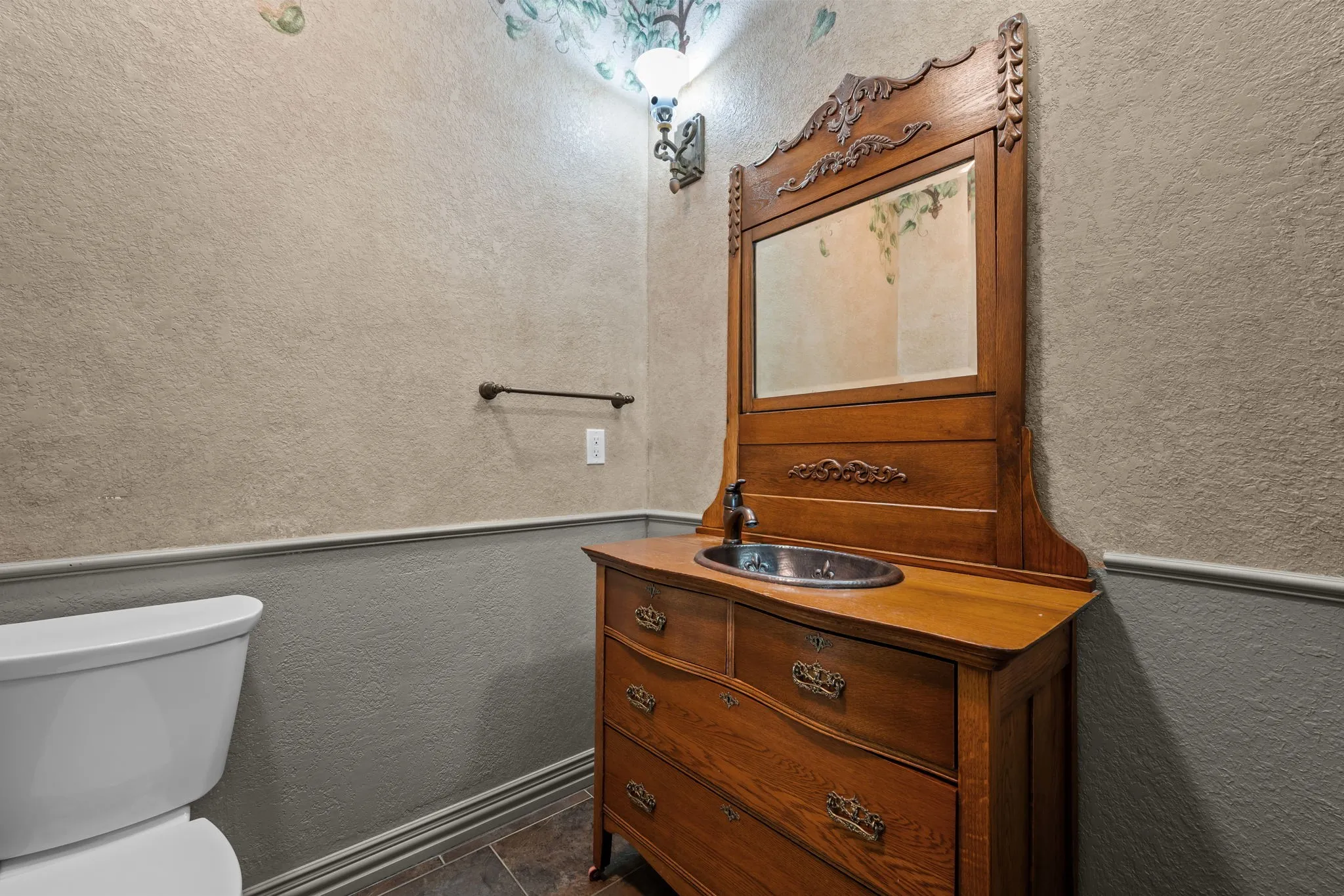 Powder bath with custom vanity, integrated sink, ornate mirror, and dark-finish faucet