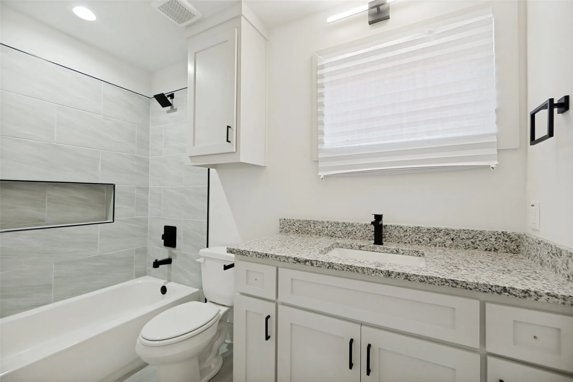 White vanity with granite countertop and integrated sink