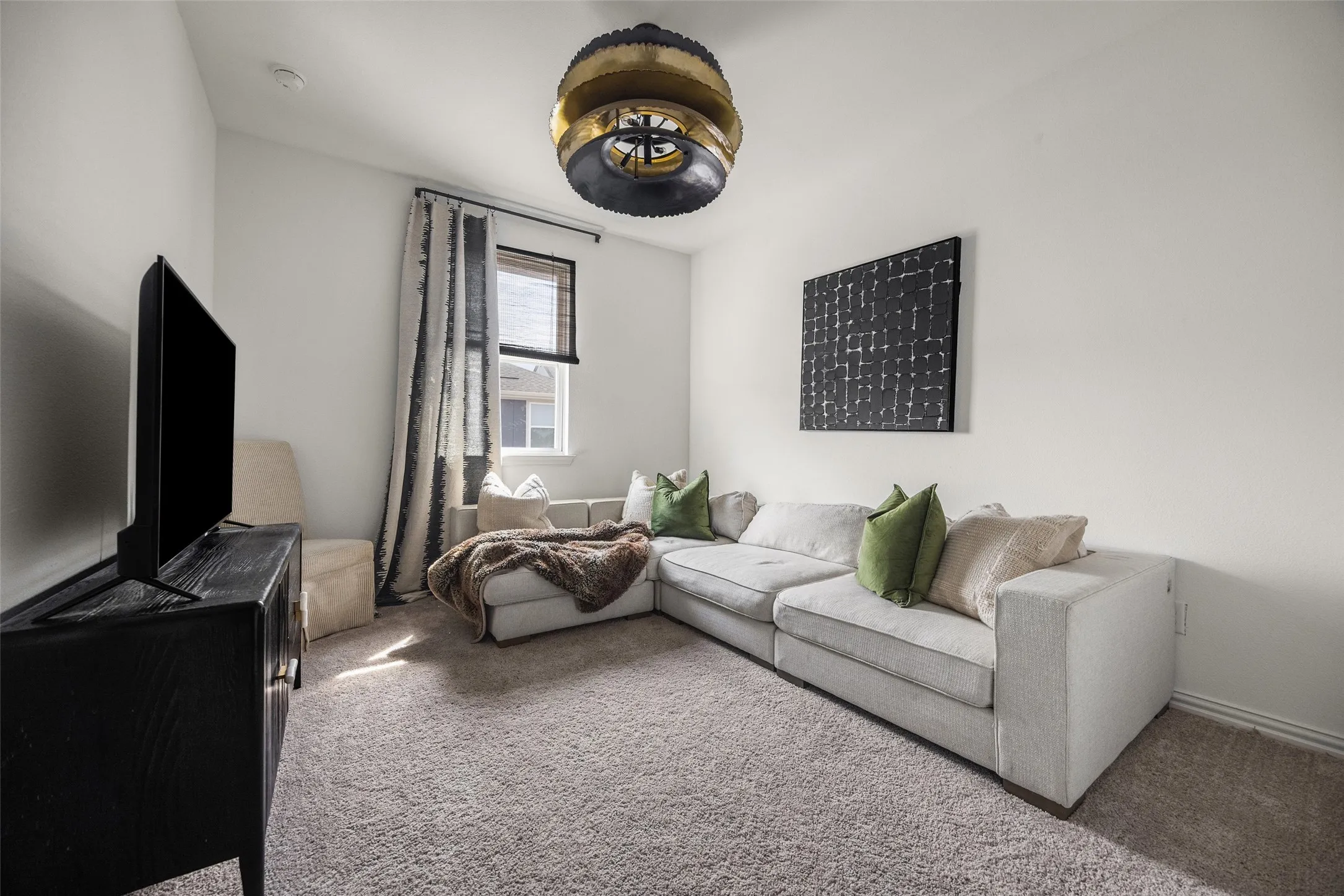 Recessed lighting and a unique ceiling fixture illuminate this carpeted room