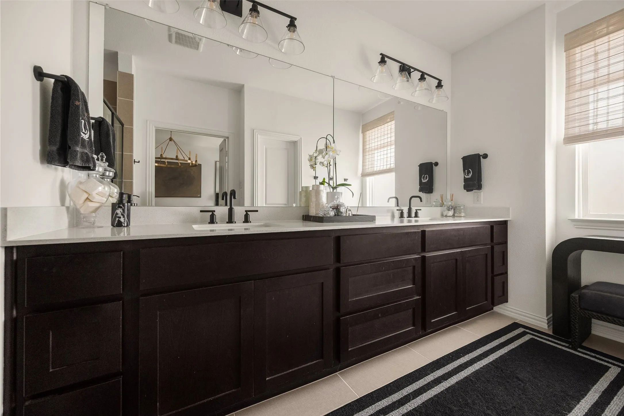 Dual vanity with dark wood-finish cabinetry, white countertops, and integrated rectangular sinks