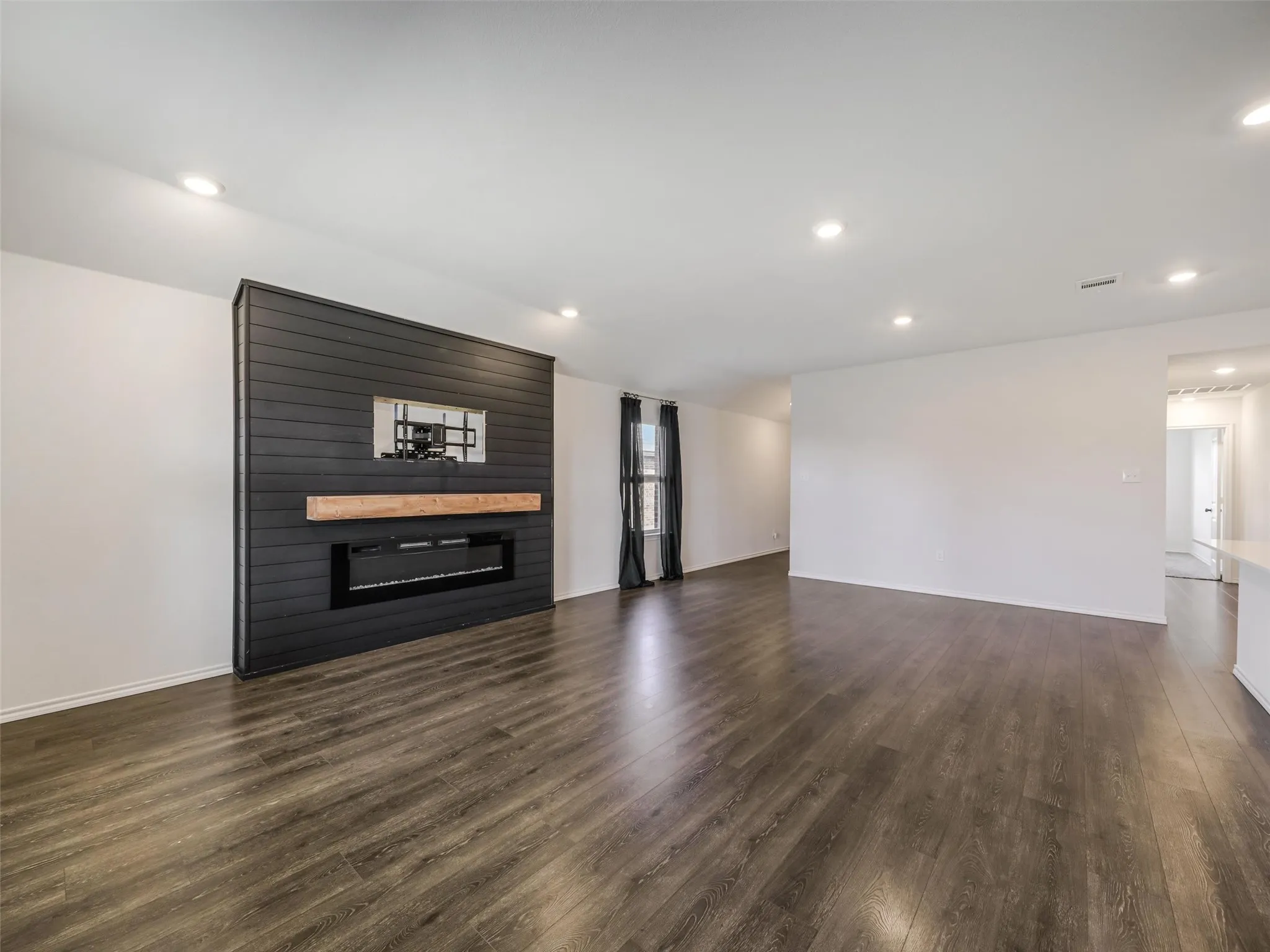Accent wall with horizontal black paneling, wood mantel, and built-in electric fireplace