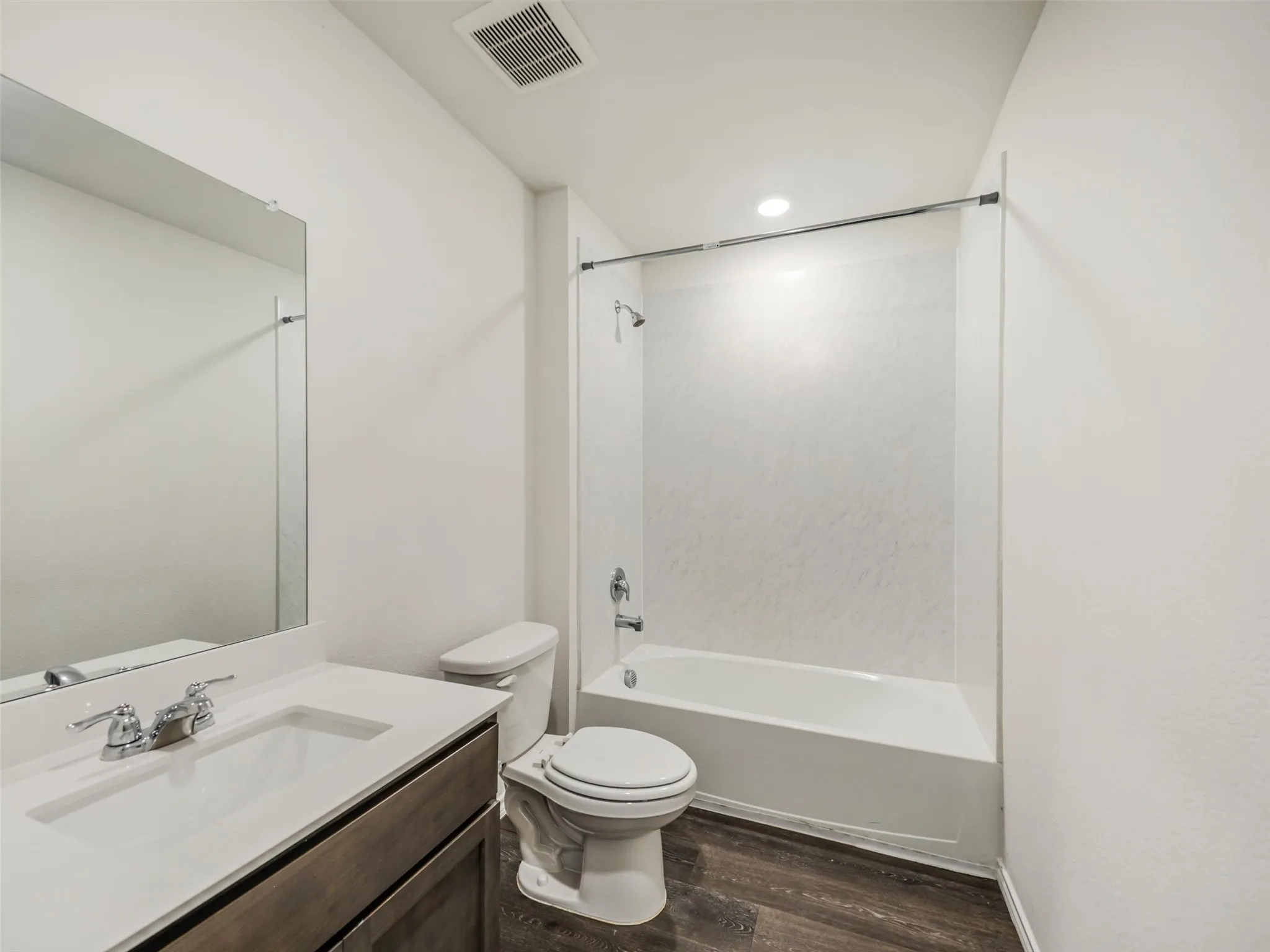 Full bathroom with a single vanity, integrated sink, and wood-finish cabinetry