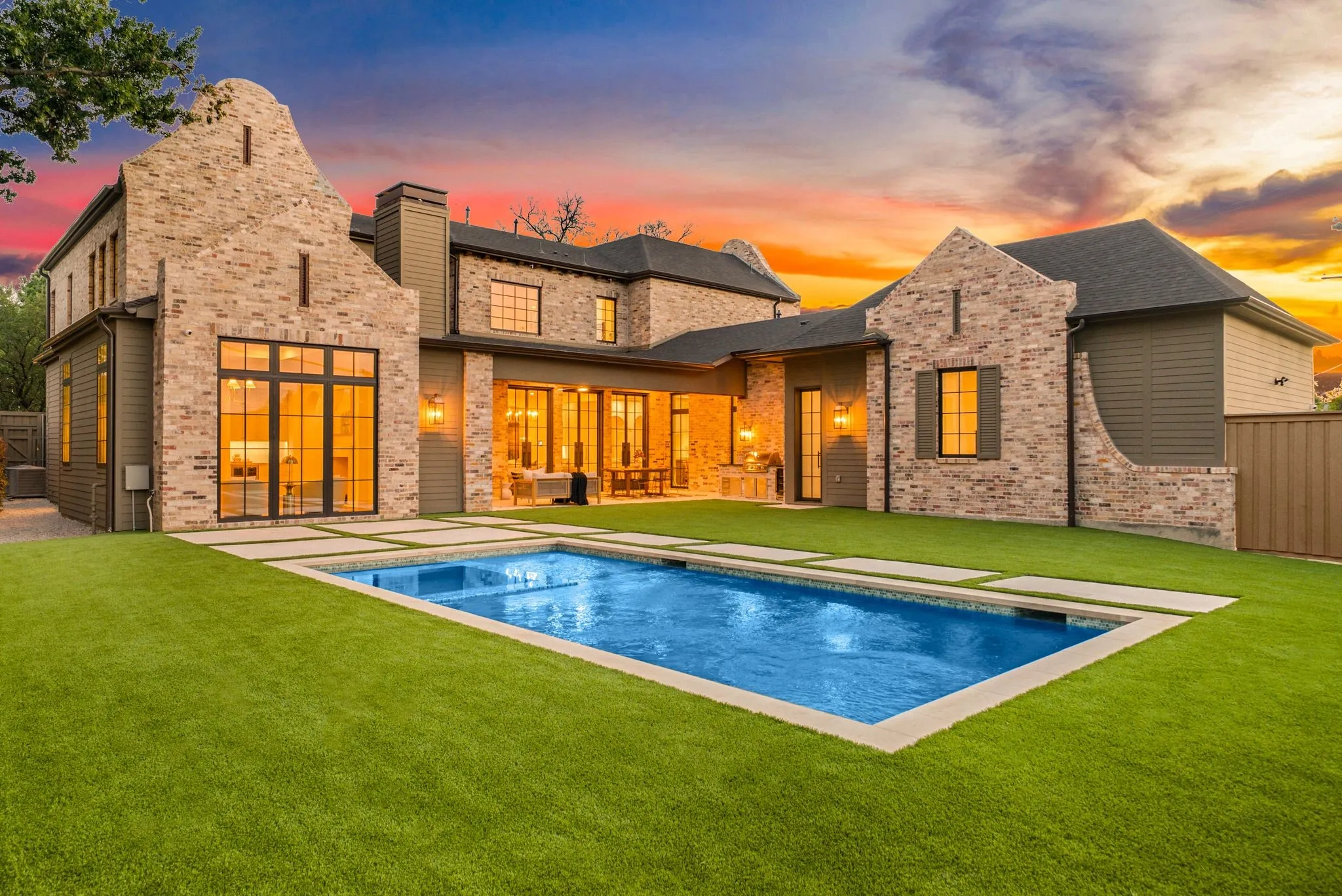 Expansive backyard featuring a rectangular swimming pool, integrated hardscaping, and a lush lawn