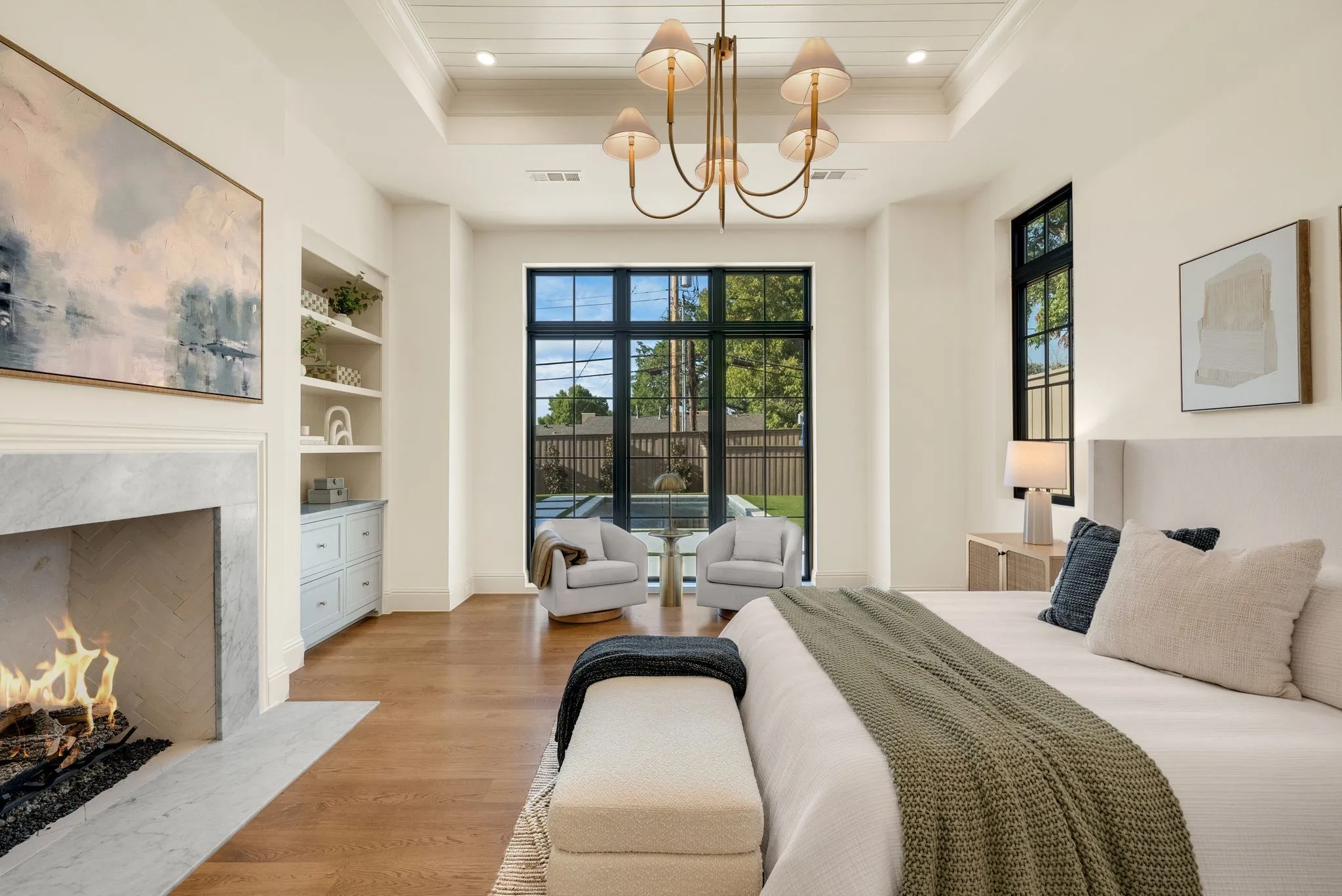 Tray ceiling with shiplap detail, recessed lighting, and a brass chandelier