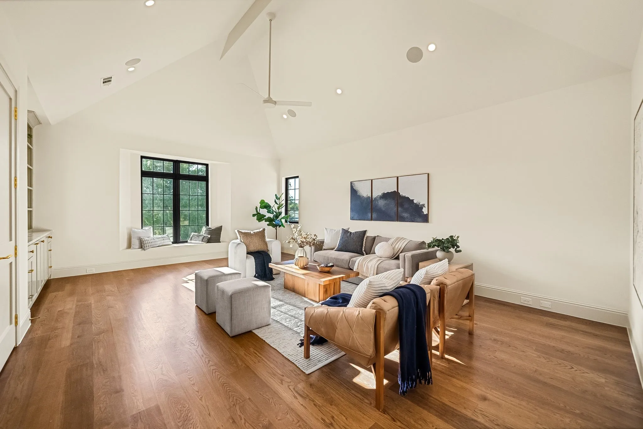 Vaulted ceiling with recessed lighting, wood-finish flooring, built-in window seating, and built-in cabinetry