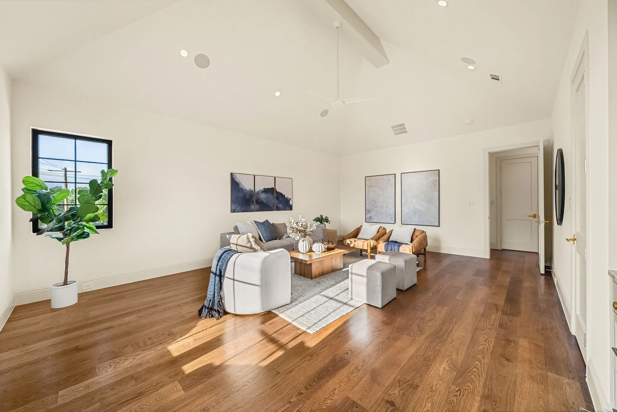 Vaulted ceiling with exposed beam, recessed lighting, wood-finish flooring, and a window with black trim