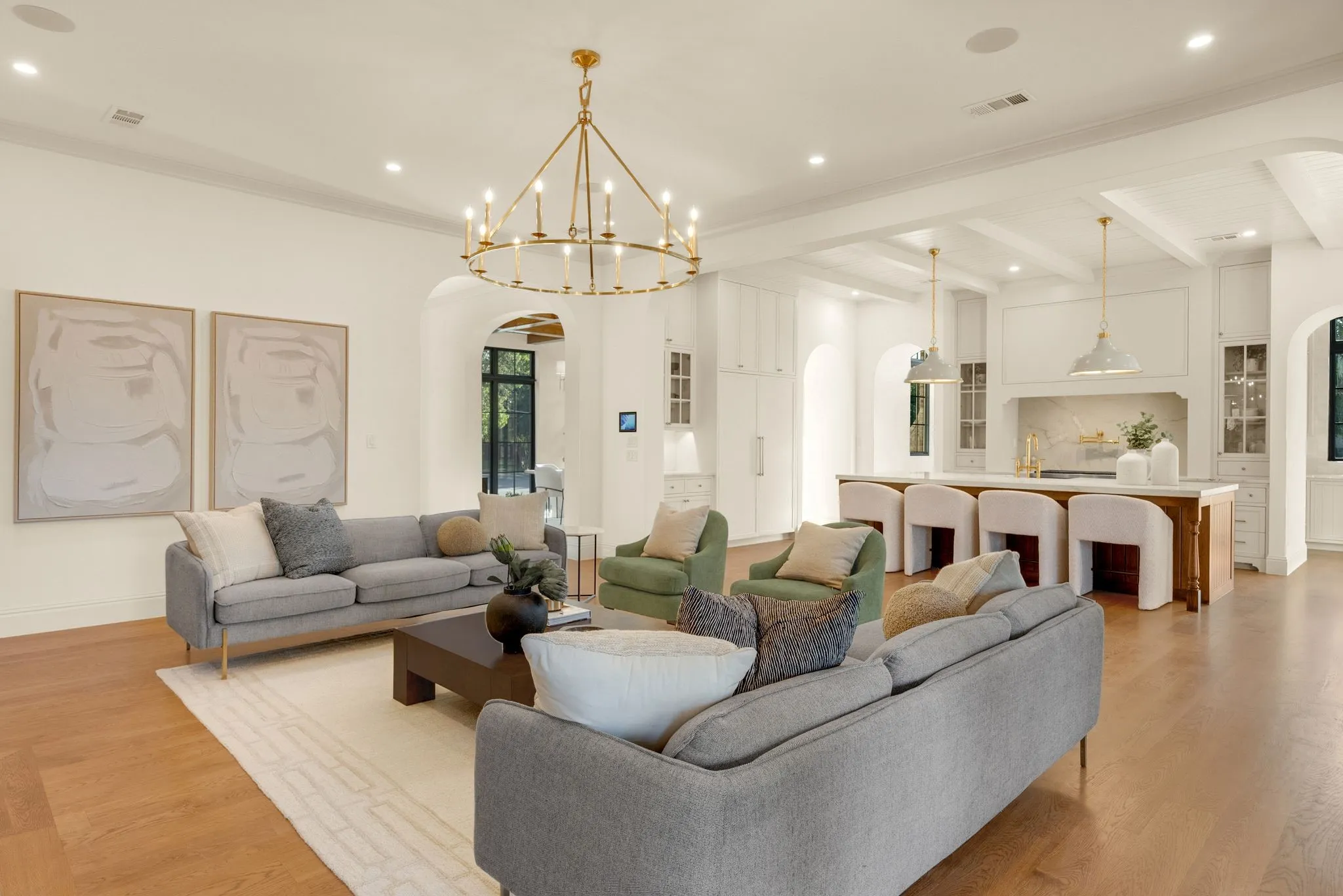 Open-concept living space featuring hardwood flooring, recessed ceiling lighting, and a brass chandelier