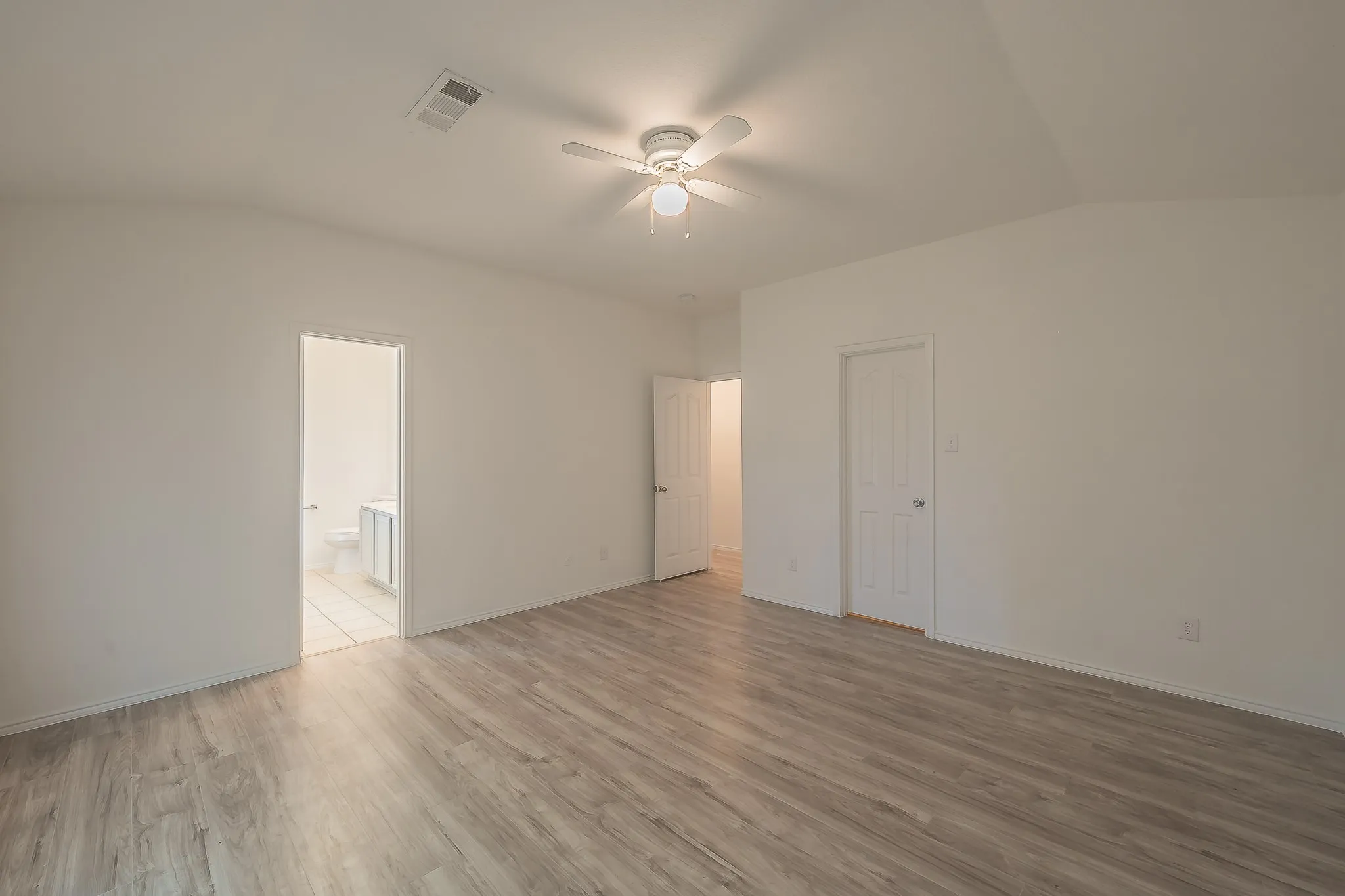 Wood-finish flooring, vaulted ceiling, and ceiling fan