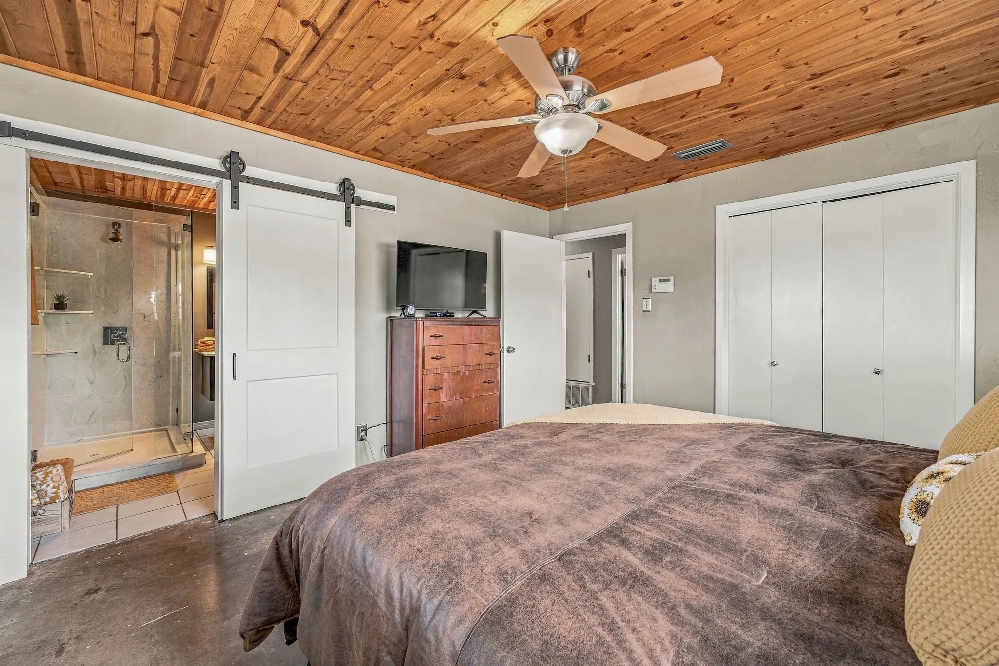 Wood-finish planked ceiling with a ceiling fan