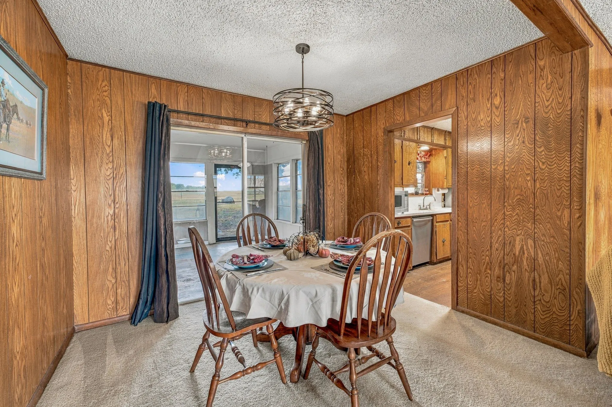 Wood-paneled walls and a circular drum chandelier