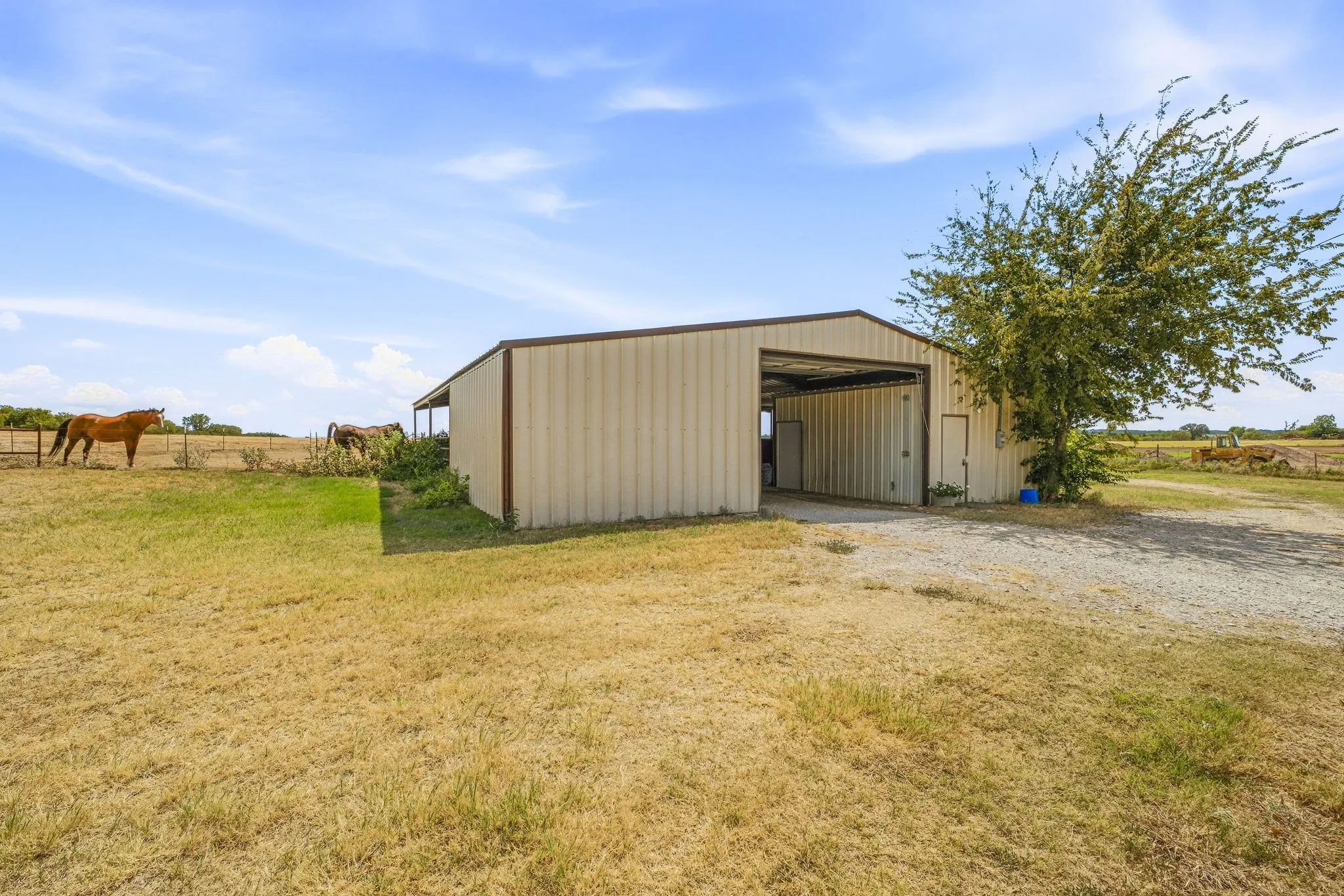 Metal-sided barn featuring an open bay and an additional entry door