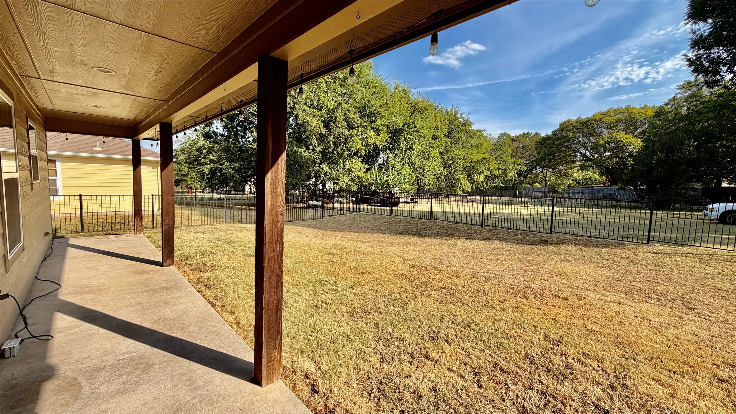 Covered concrete patio with wood-finish support columns