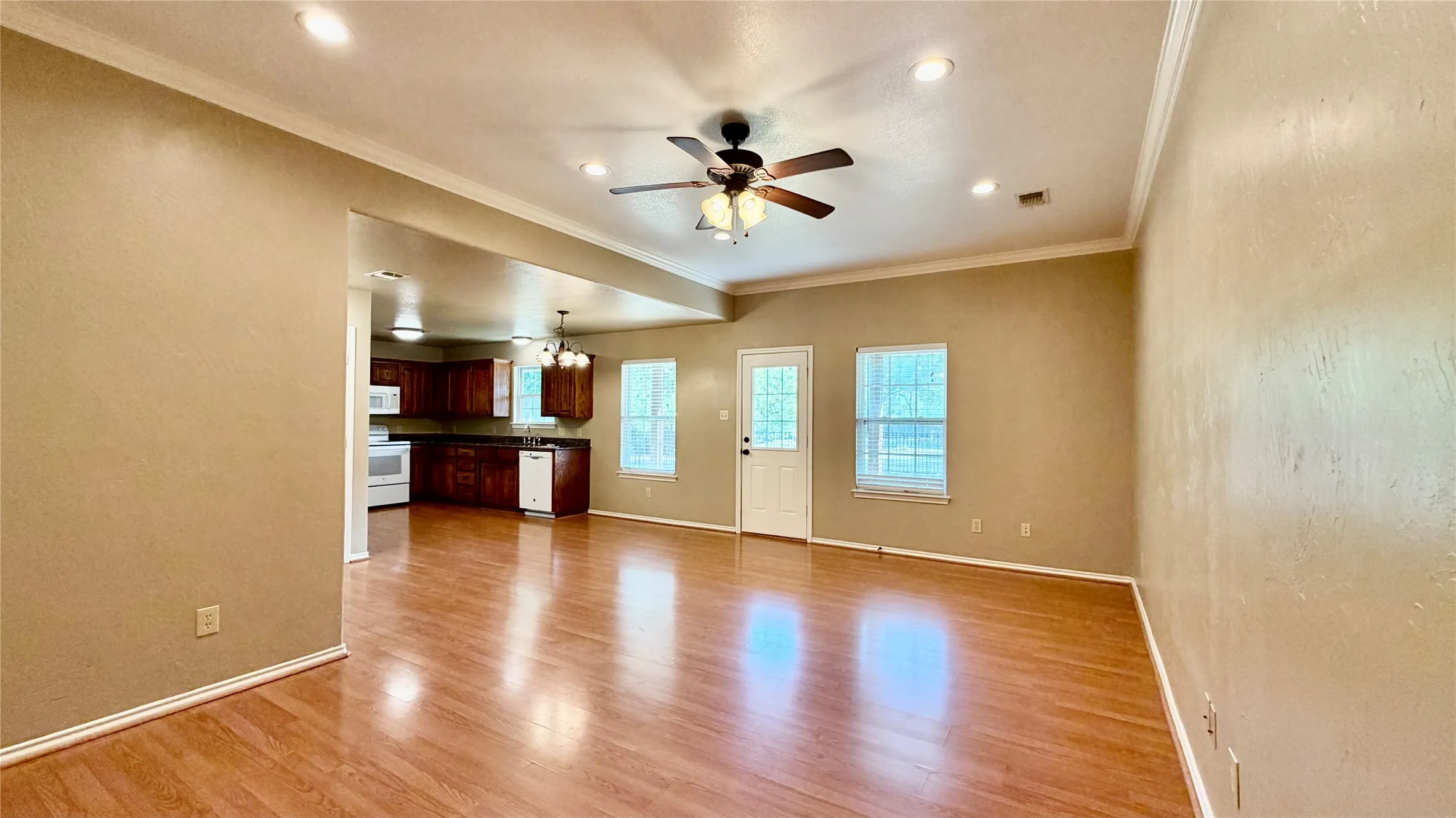 Open-concept living area with wood-finish flooring, recessed lighting, and a ceiling fan