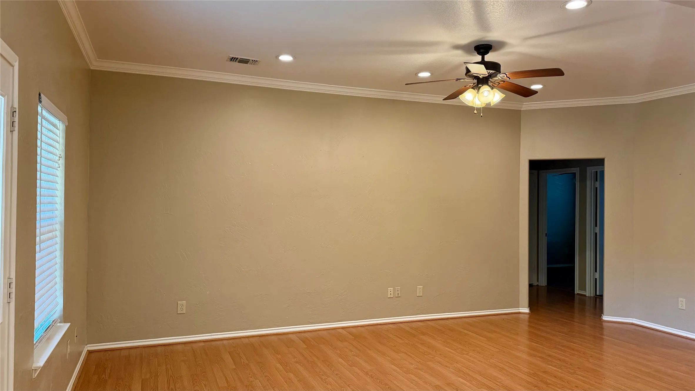 Wood-finish flooring, recessed lighting, crown molding, and a ceiling fan with light fixture